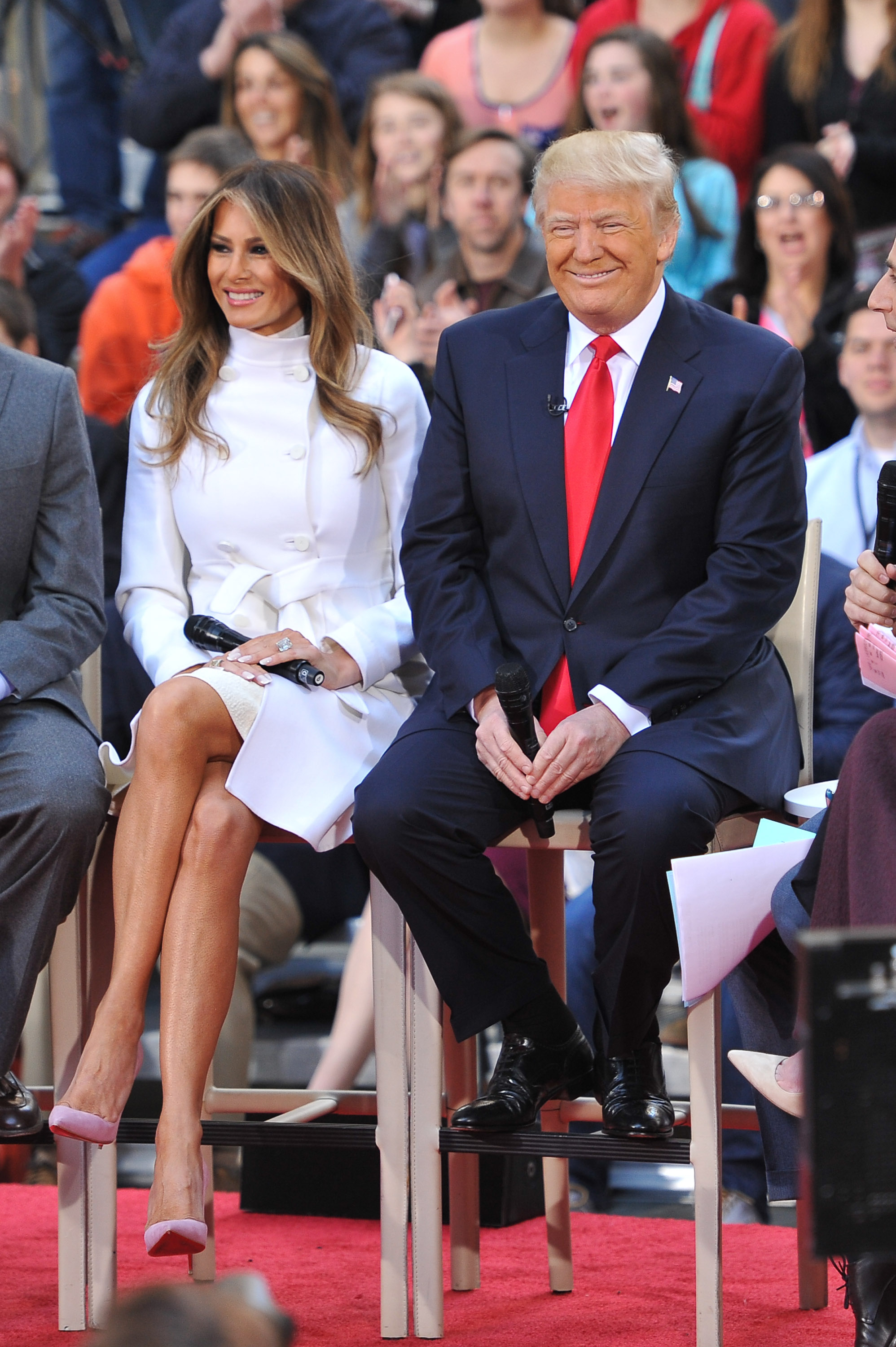 Melania Trump participe à l'émission « Today Trump Town Hall » de NBC au Rockefeller Plaza à New York, le 21 avril 2016, vêtue d’un manteau blanc à double boutonnage ceinturé, porté par-dessus un col roulé ivoire, rehaussé d’escarpins à bout pointu en daim rose poudré qui apportent une touche pastel délicate à ses talons aiguilles vertigineux.