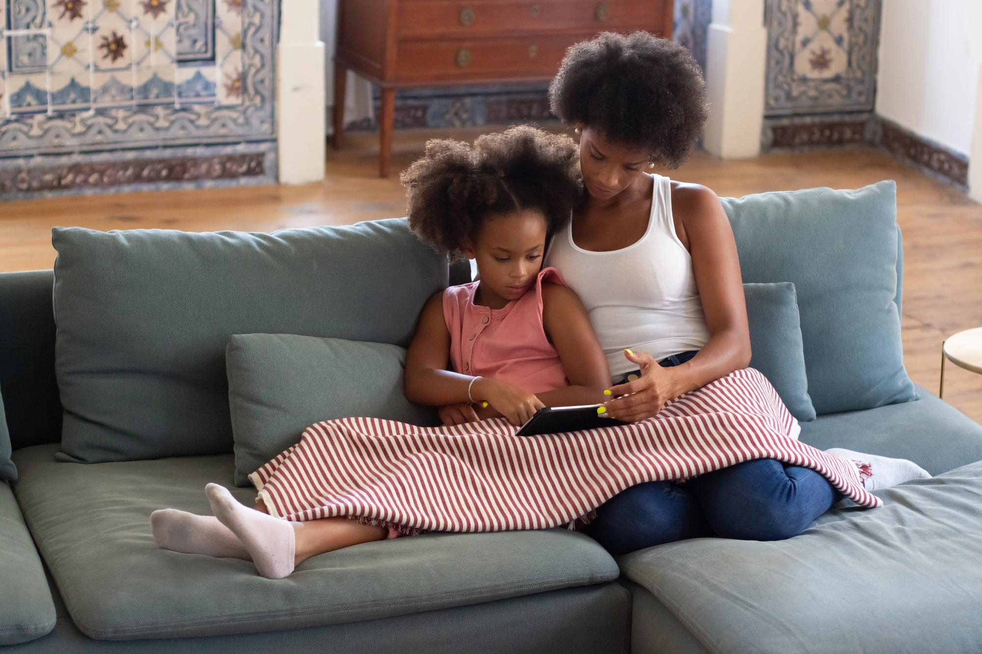 Une jeune femme se lie avec une petite fille tout en utilisant une tablette | Source : Freepik