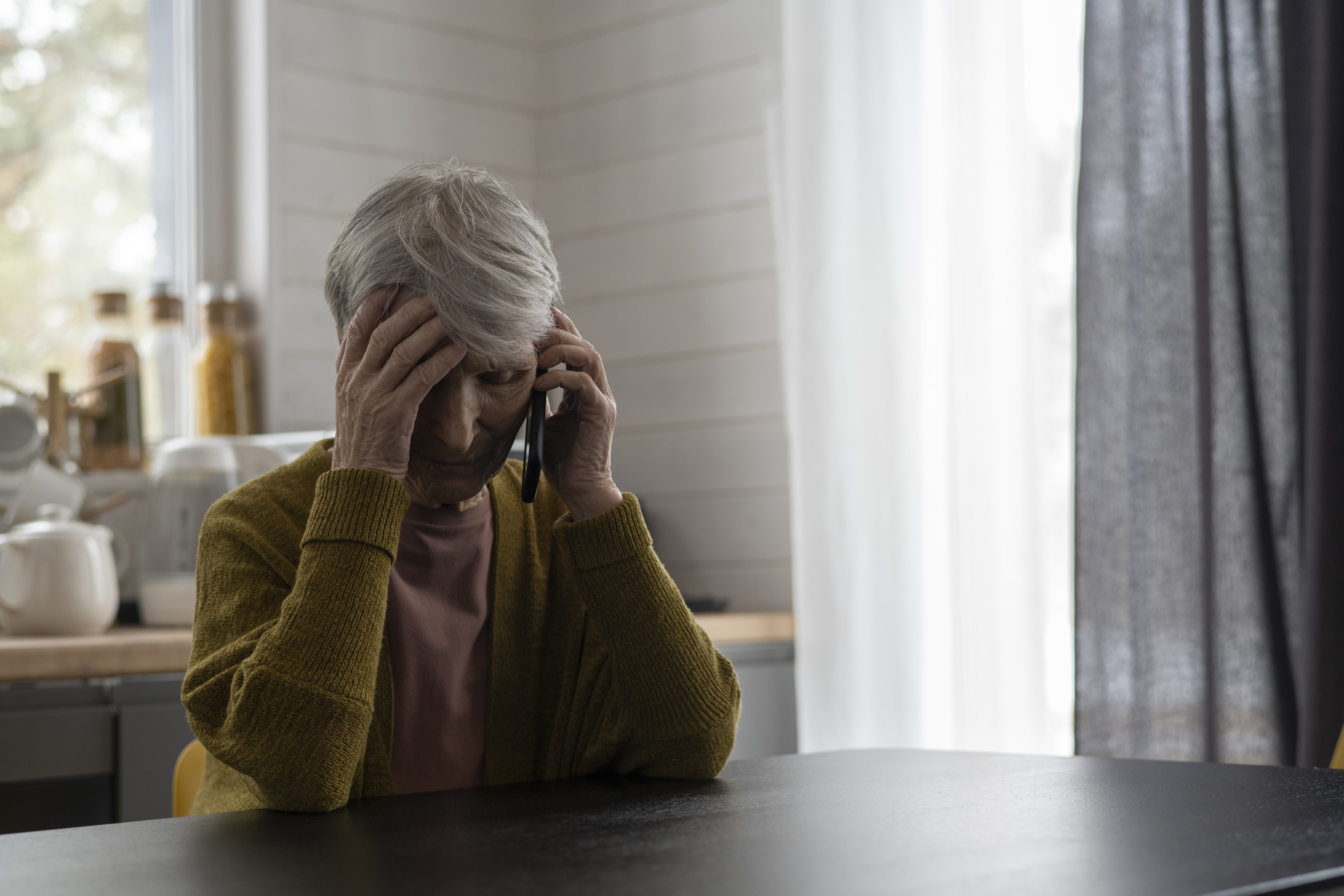 Une femme âgée triste lors d'un appel téléphonique | Source : Freepik
