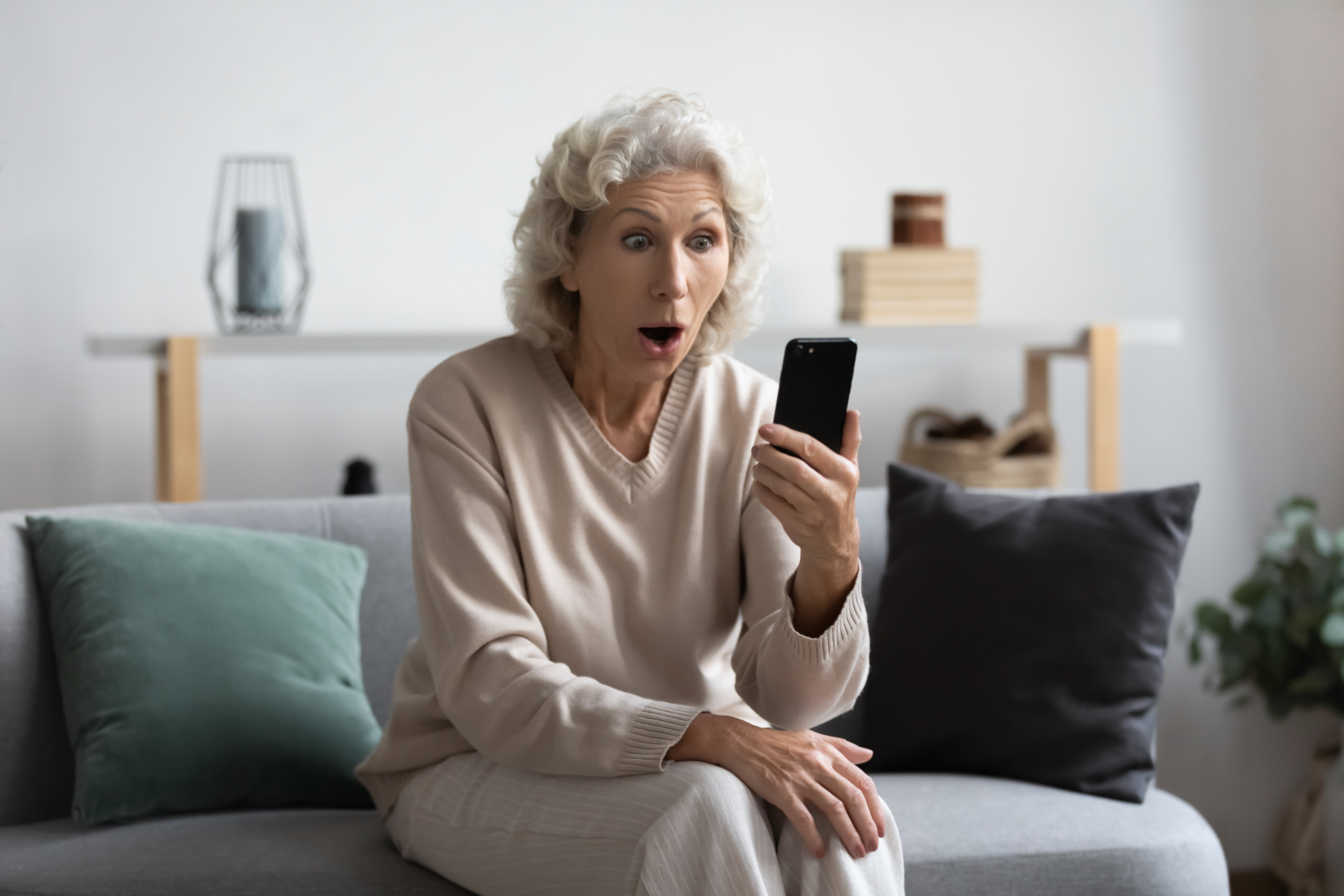 Image d'une femme âgée lisant quelque chose de choquant sur son téléphone. | Source : Shutterstock/fizkes