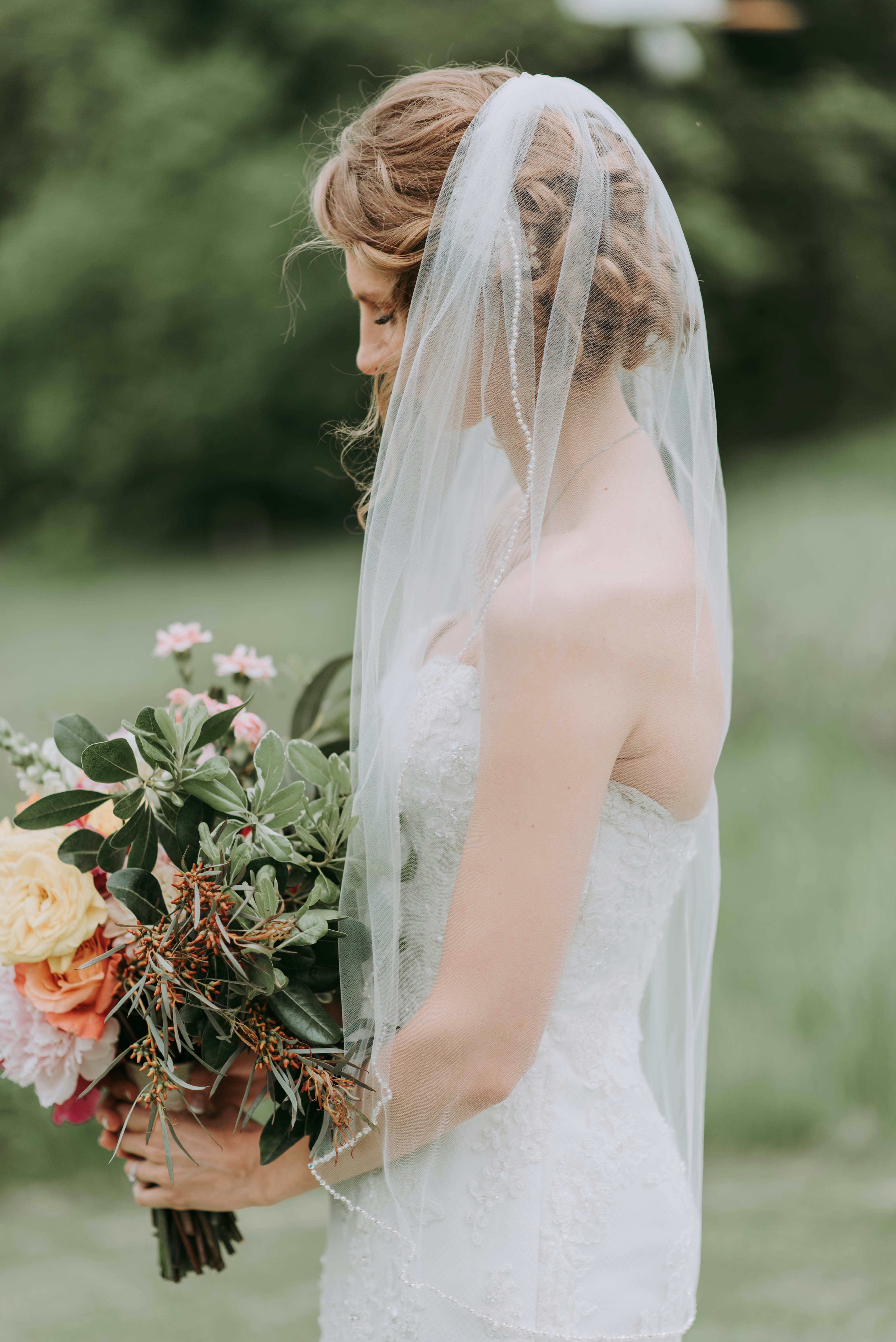 Une mariée triste tenant un bouquet de fleurs | Source : Unsplash