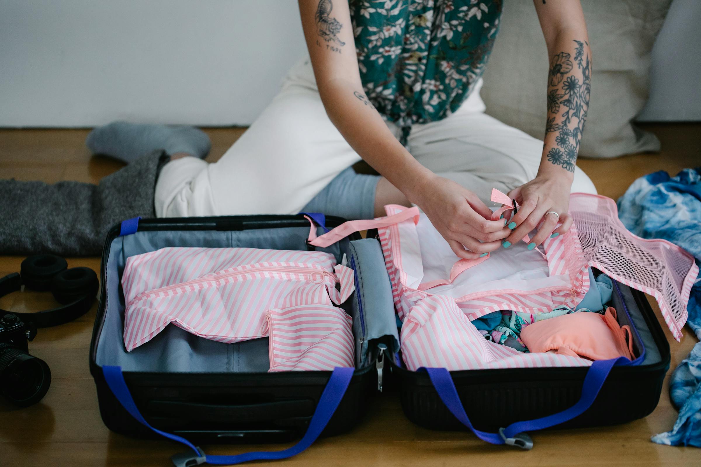 Une femme emballe des vêtements dans une valise | Source : Pexels