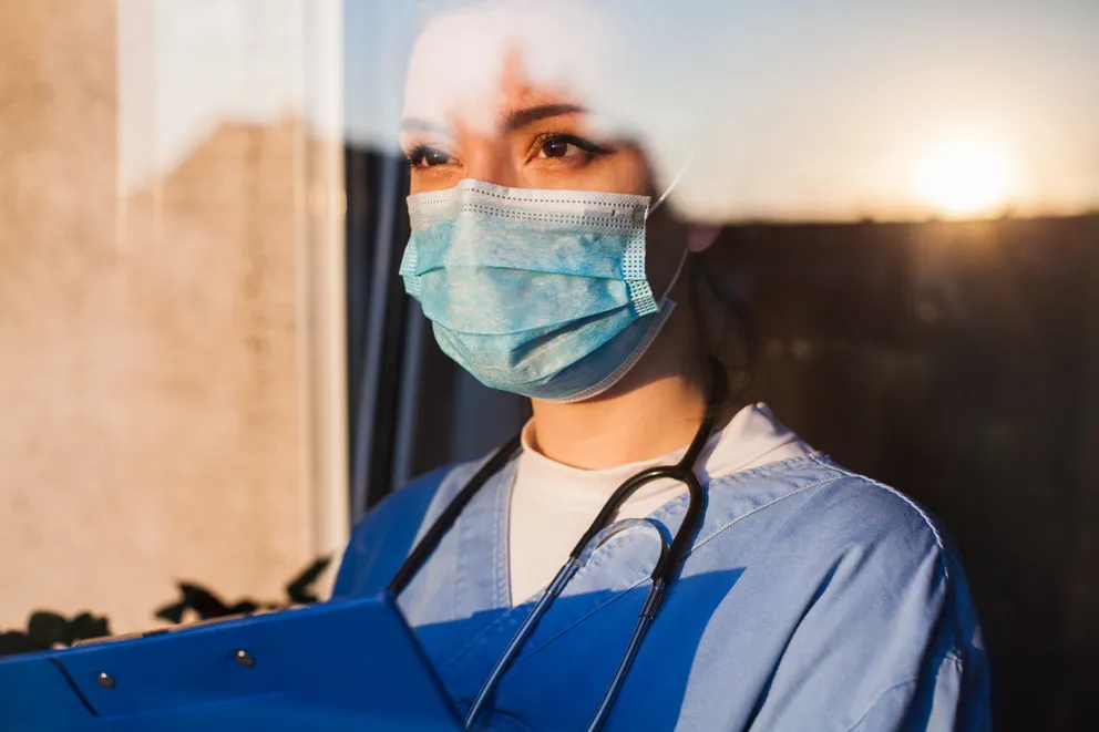 Une infirmière regardant fixement alors qu'elle contemple le paysage : Shutterstock