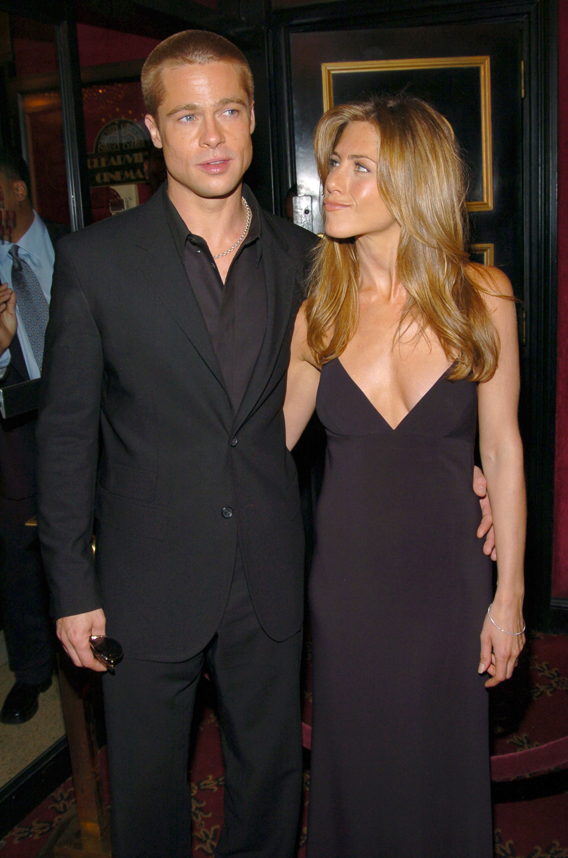 Brad Pitt et Jennifer Aniston sont arrivés ensemble à la première new-yorkaise du film « Troie » ; Jennifer Aniston a le regard tourné vers Brad Pitt alors que le couple pose côte à côte pour les photographes devant le cinéma.