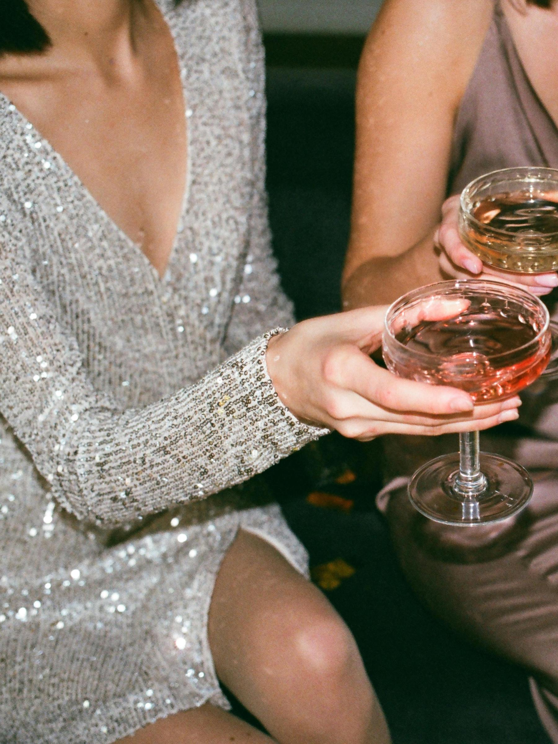 Une femme vêtue d'une robe éblouissante tient une coupe de champagne | Source : Pexels