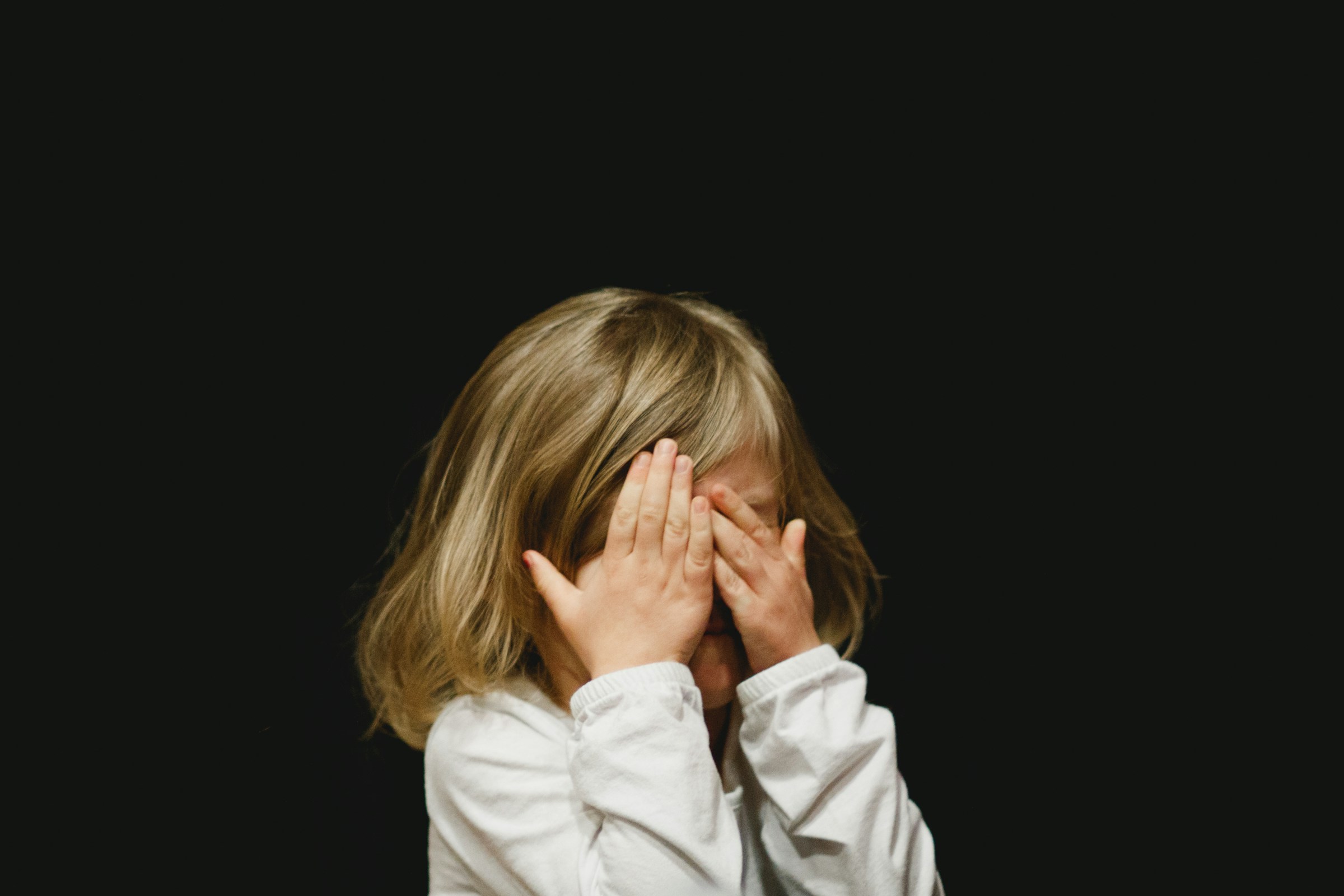 Une petite fille se couvrant le visage | Source : Unsplash