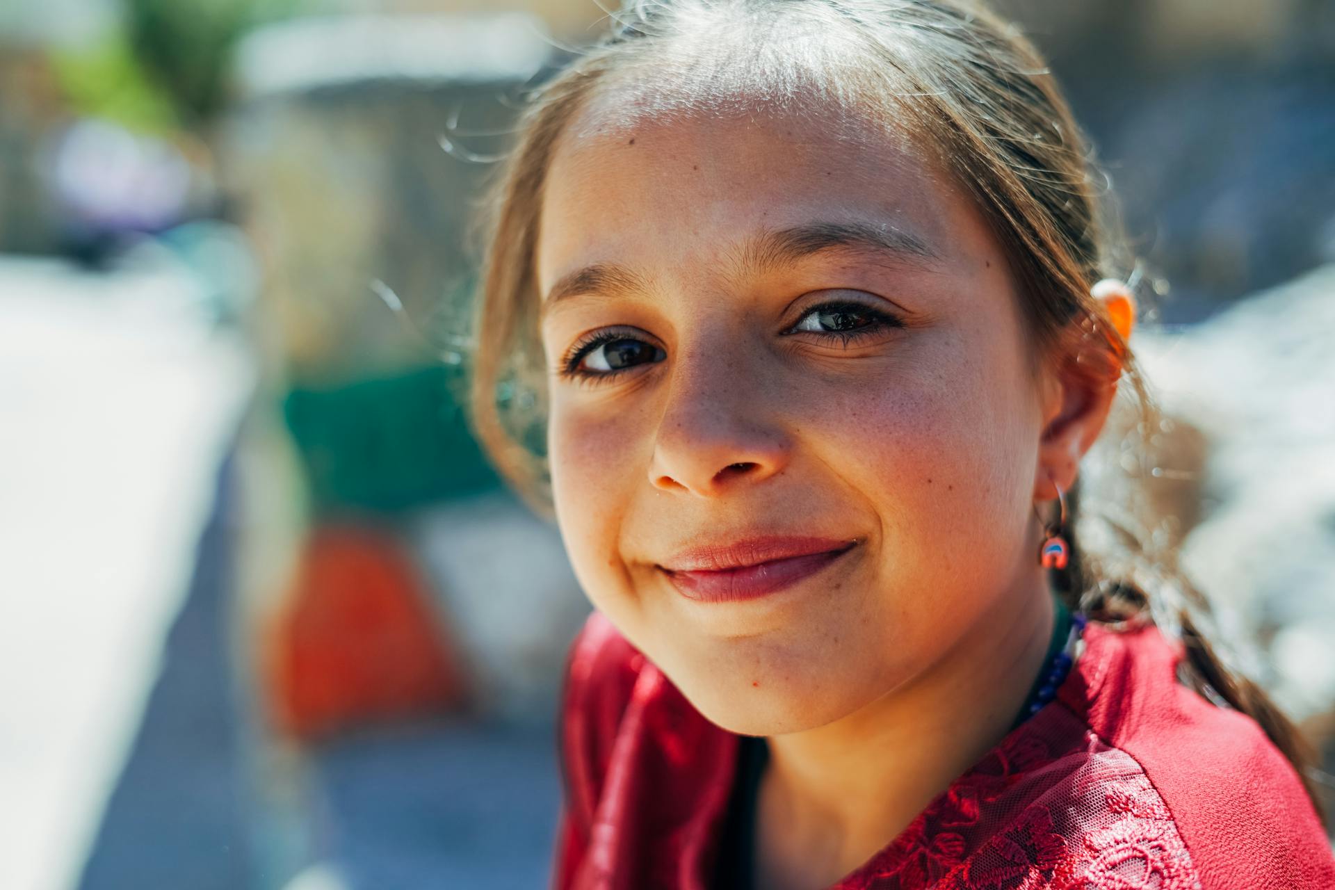 Gros plan d'une fille souriante qui regarde vers le haut | Source : Pexels