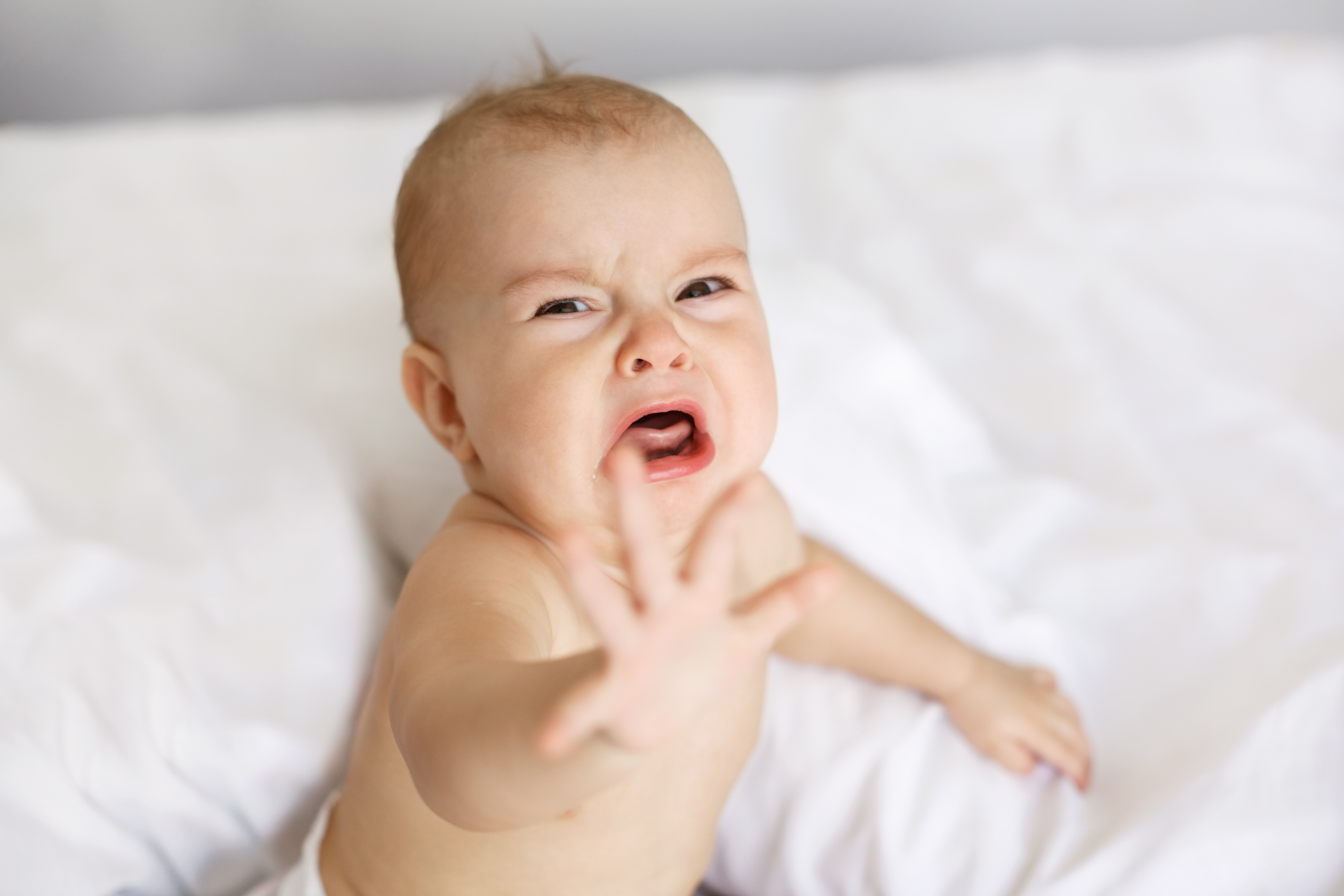 Bébé en pleurs tendant la main | Source : Shutterstock