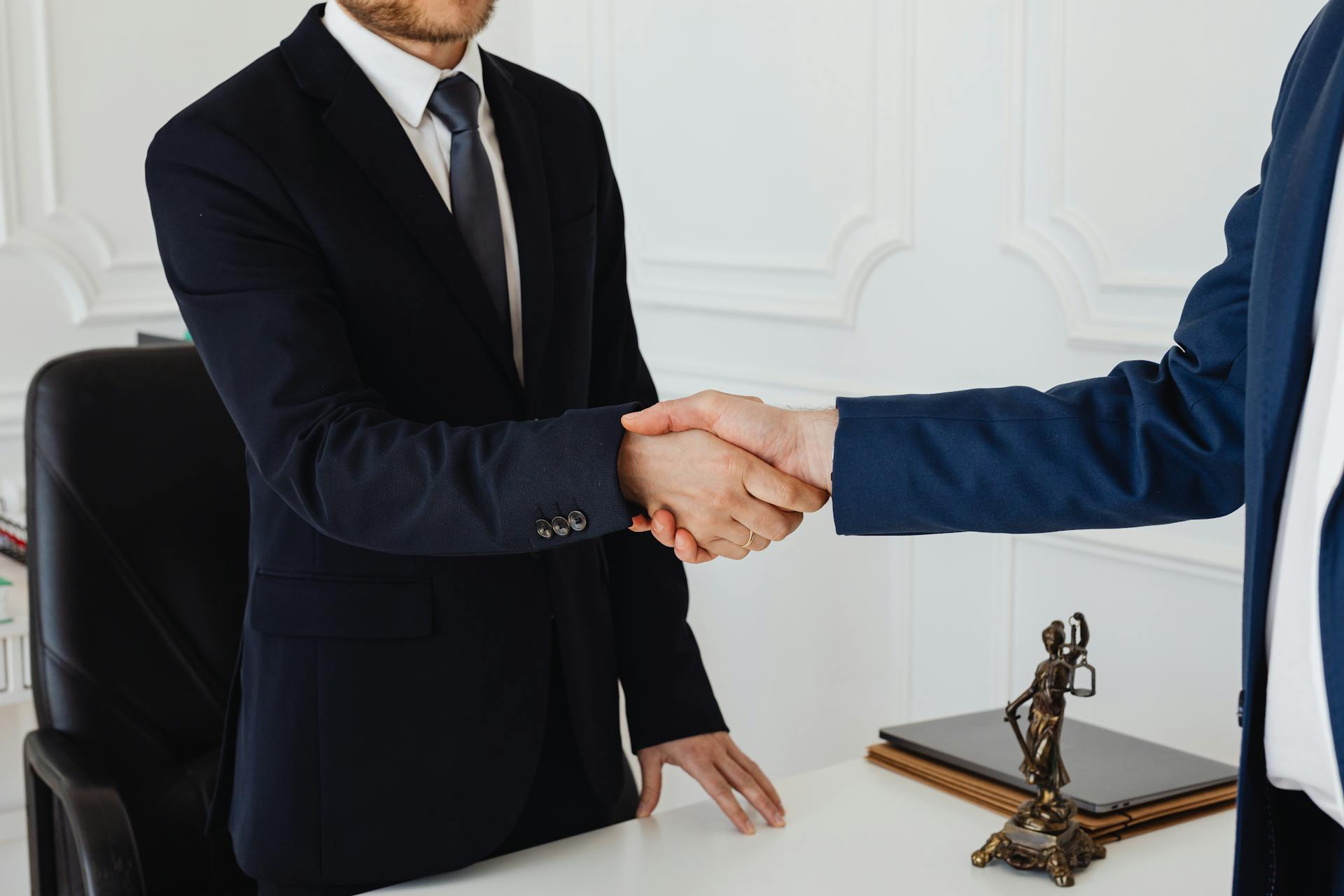 Un gros plan de deux hommes se serrant la main dans un cadre formel | Source : Pexels