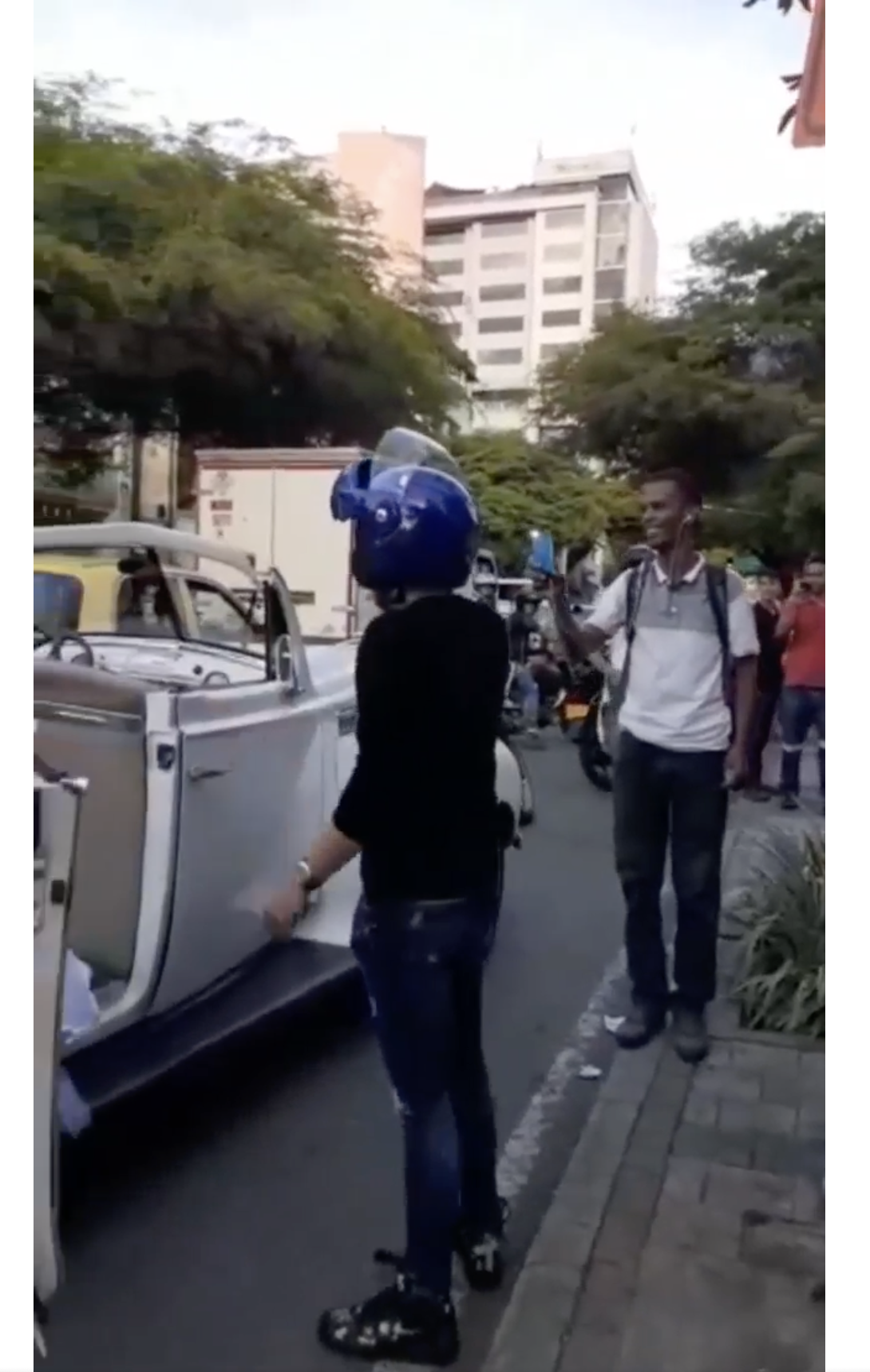 Le motard et un spectateur qui a filmé l'incident sont photographiés sur le bord de la route à Medellin, en Colombie | Source : facebook.com/maspopulareventos