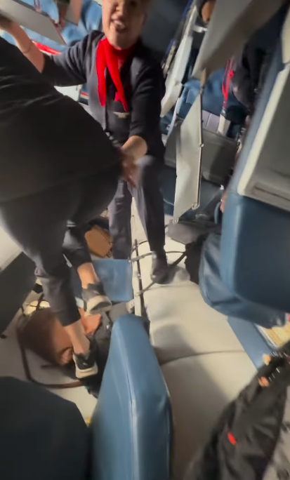 À l'intérieur de l'avion, une hôtesse de l'air aide les passagers à se frayer un chemin parmi les sièges renversés et les débris éparpillés | Source : Instagram.com/eggxit