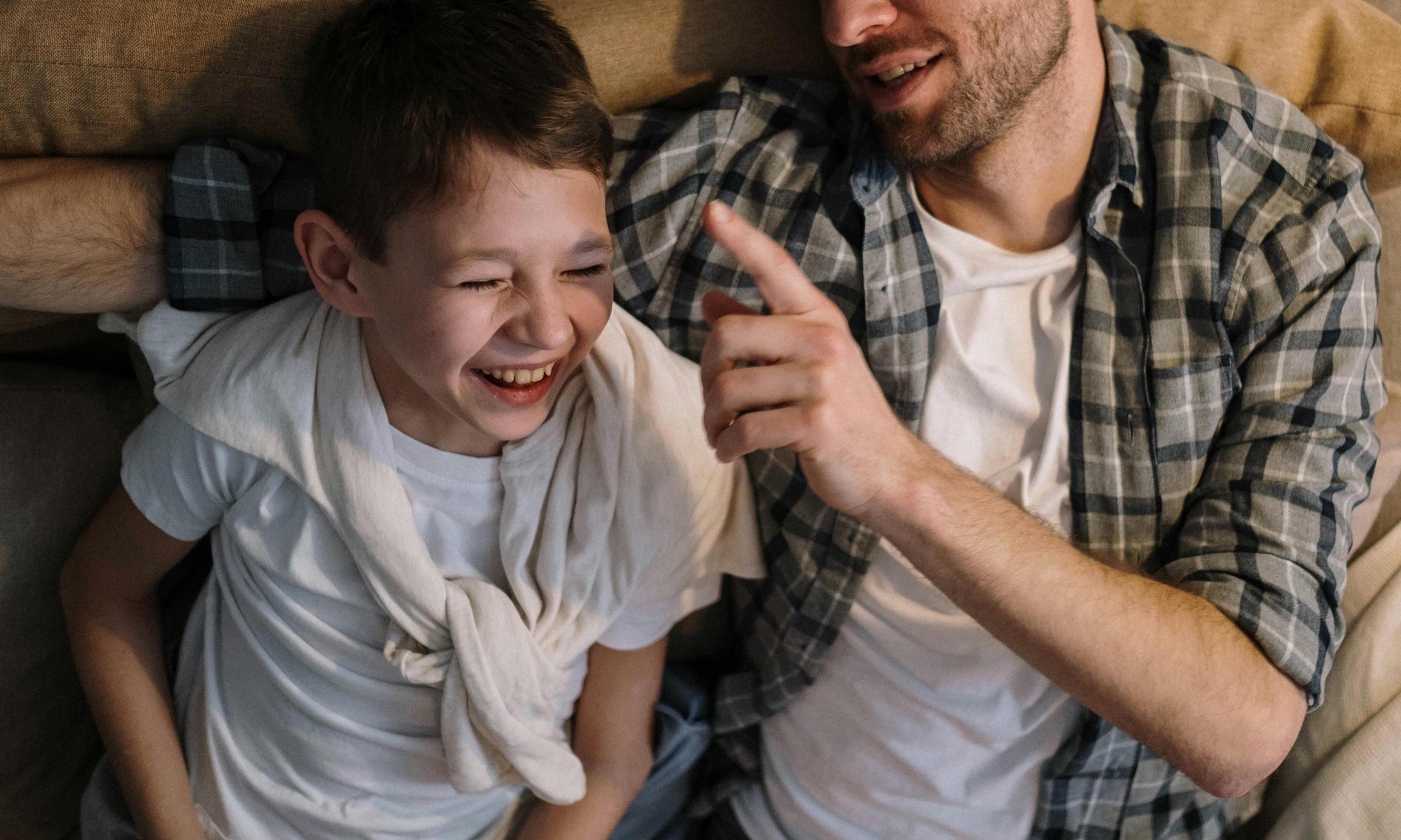 Un homme et un garçon qui rient ensemble | Source : Pexels