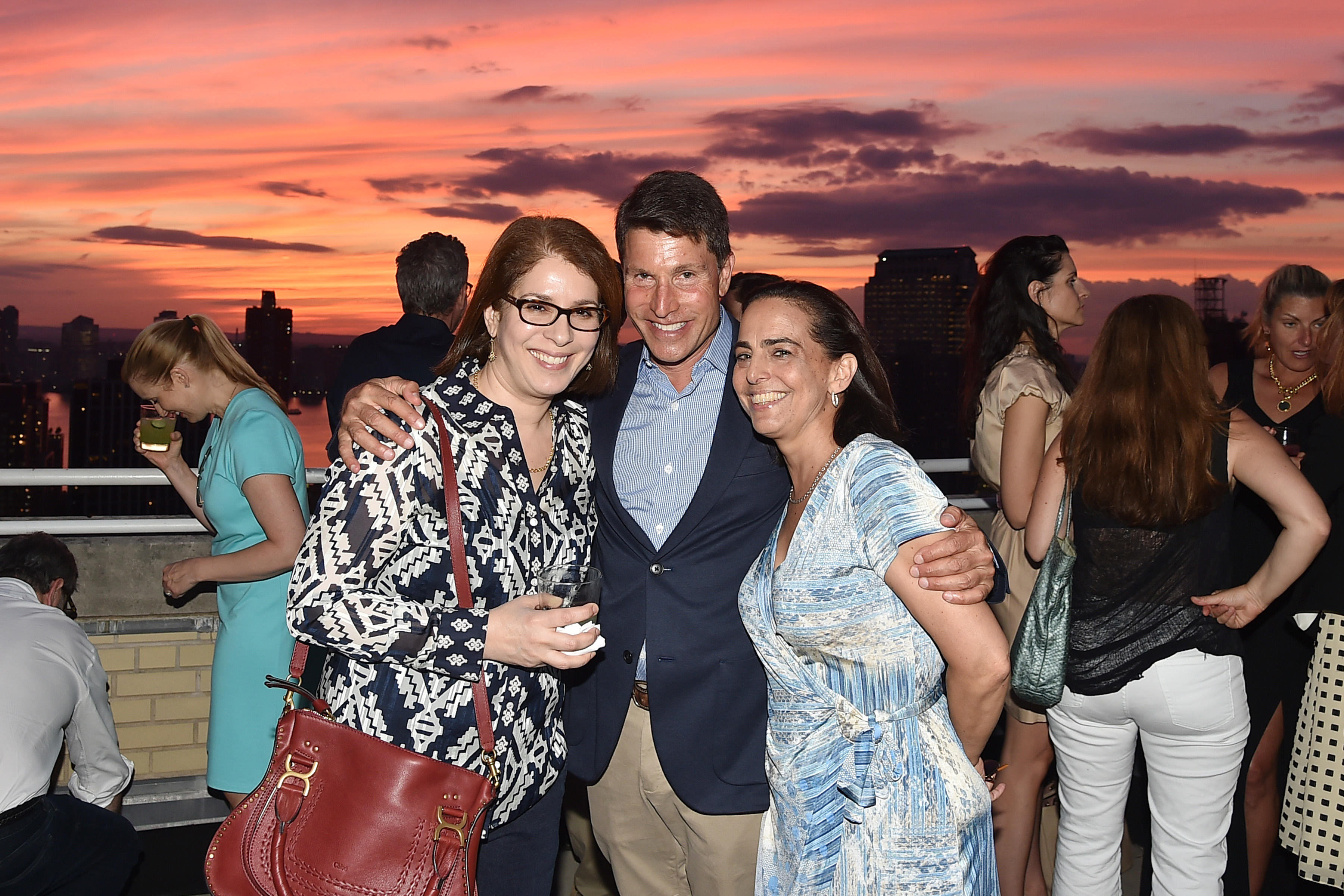 Neda Morvillo pose pour une photo avec des invités lors de l'événement Summer Birthday Cocktails For Lawrence Kaplan à New York le 21 juin 2018 | Source : Getty Images