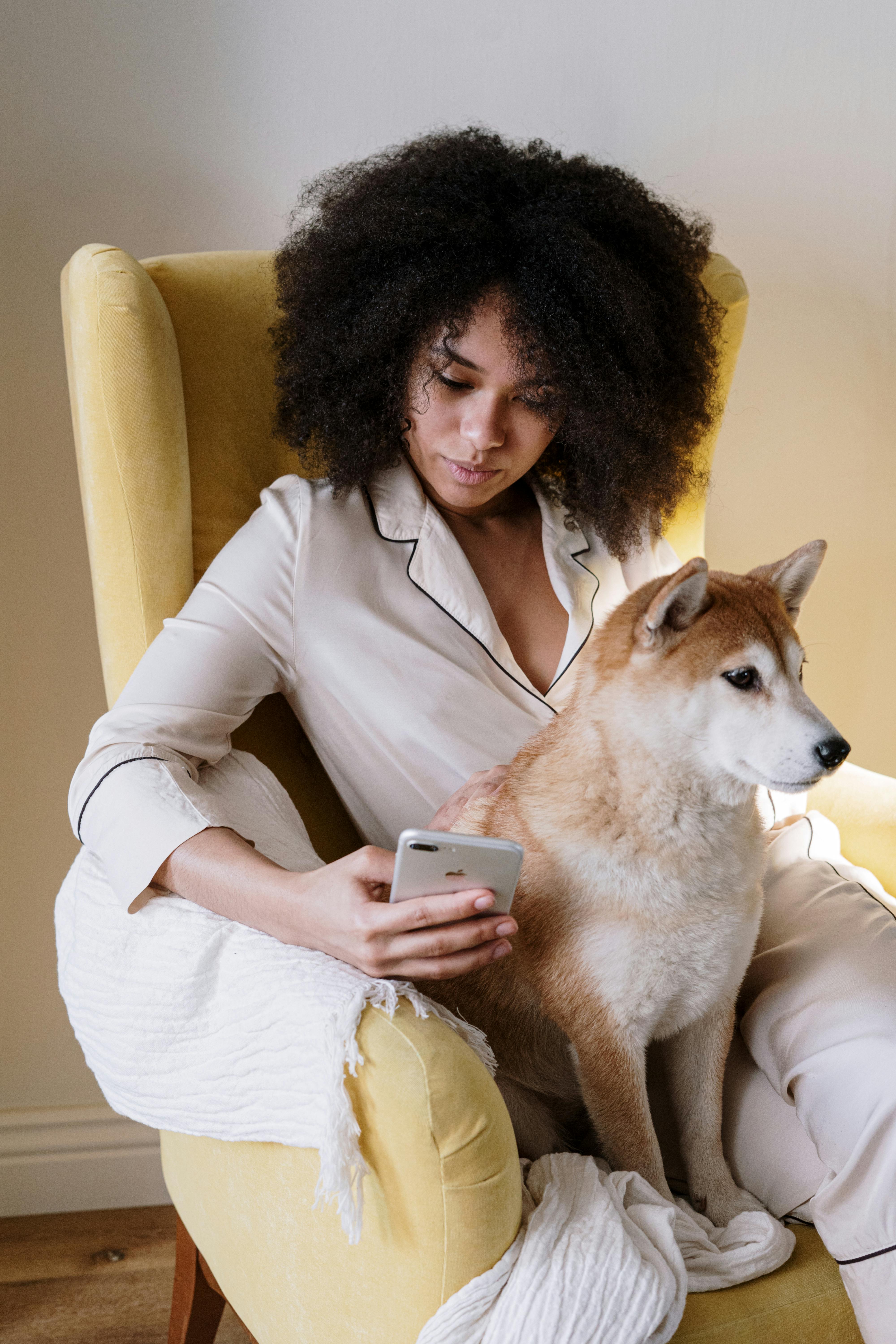 Une femme en pyjama assise avec son chien | Source : Pexels