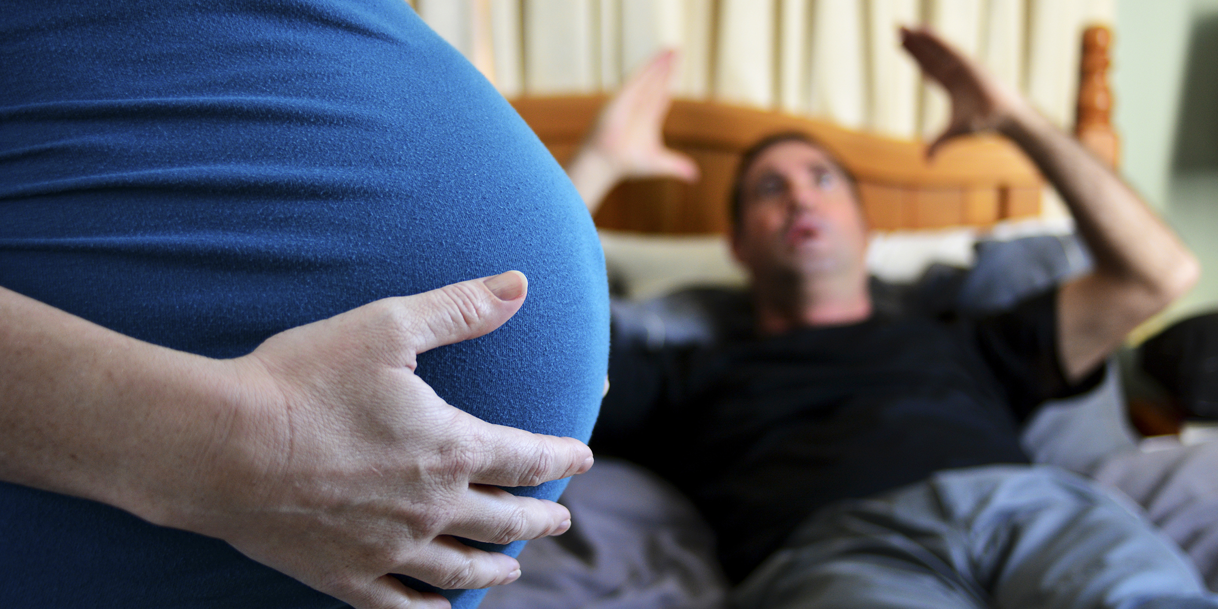 Une femme enceinte avec un homme en colère en arrière-plan | Source : Shutterstock