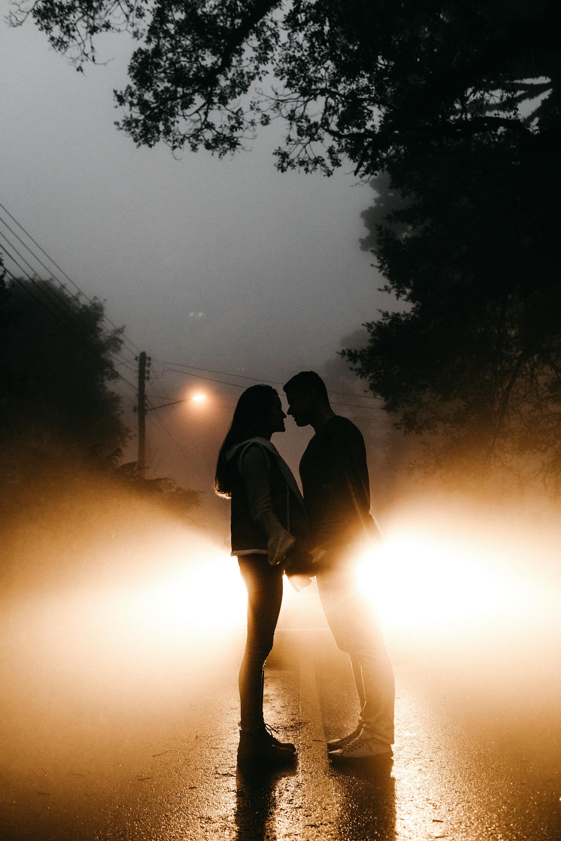Une prise de vue lointaine d'un couple debout sur la route tout en se tenant par la main | Source : Pexels