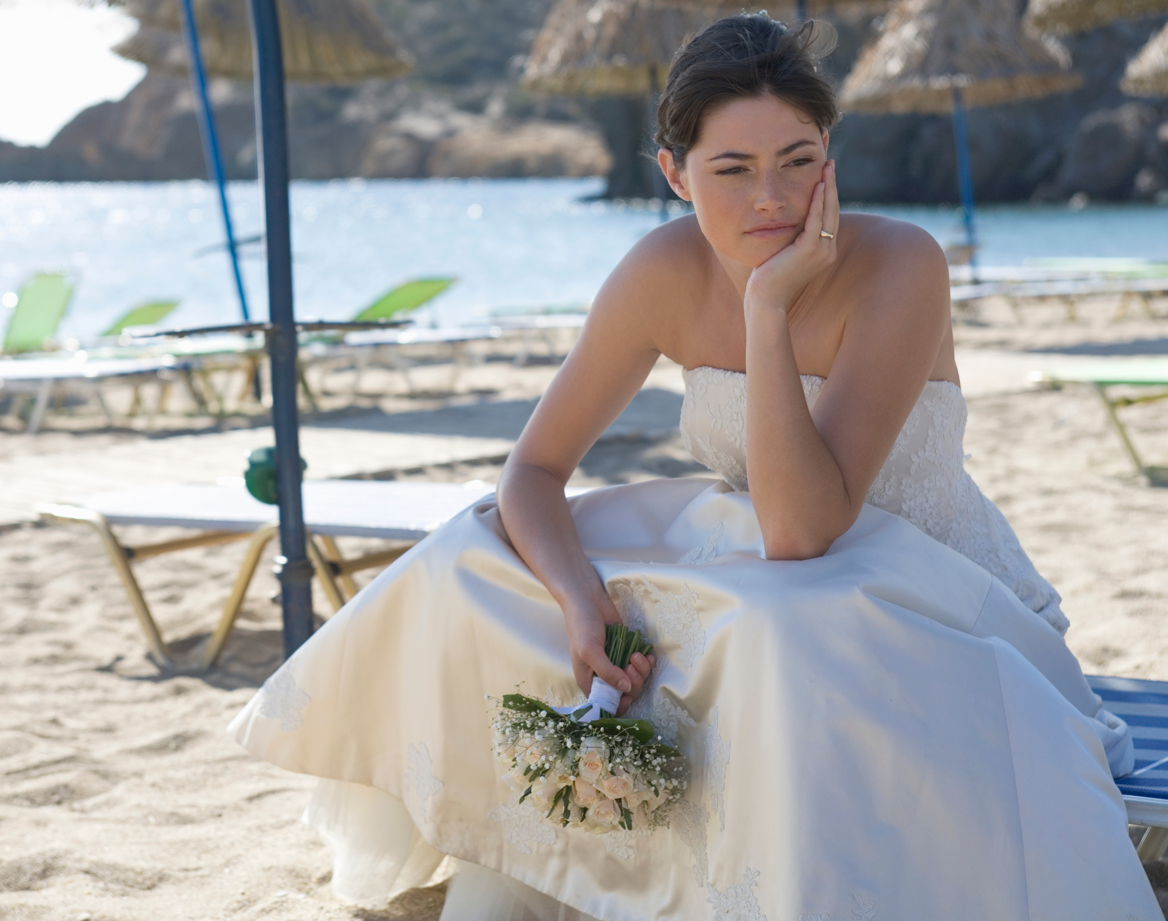 Une mariée malheureuse est photographiée assise sur une plage | Source : Shutterstock