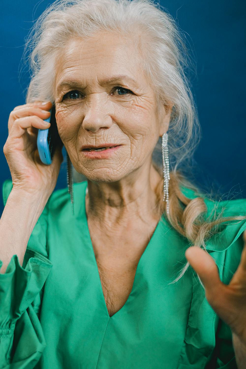 Une femme en robe verte qui parle au téléphone | Source : Pexels