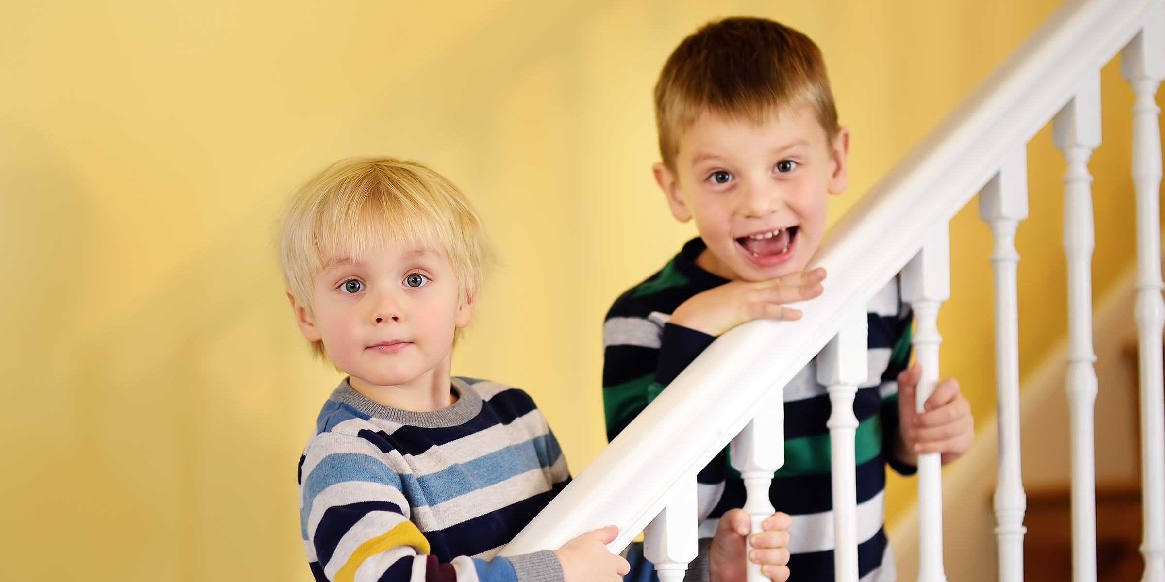 Deux garçons debout sur un escalier | Source : Shutterstock