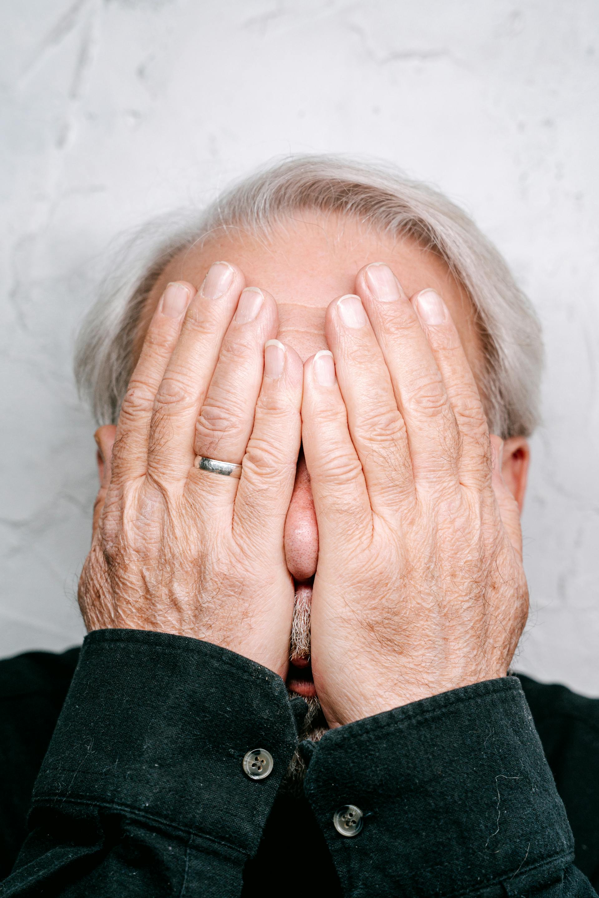 A sad man covering his face | Source: Pexels