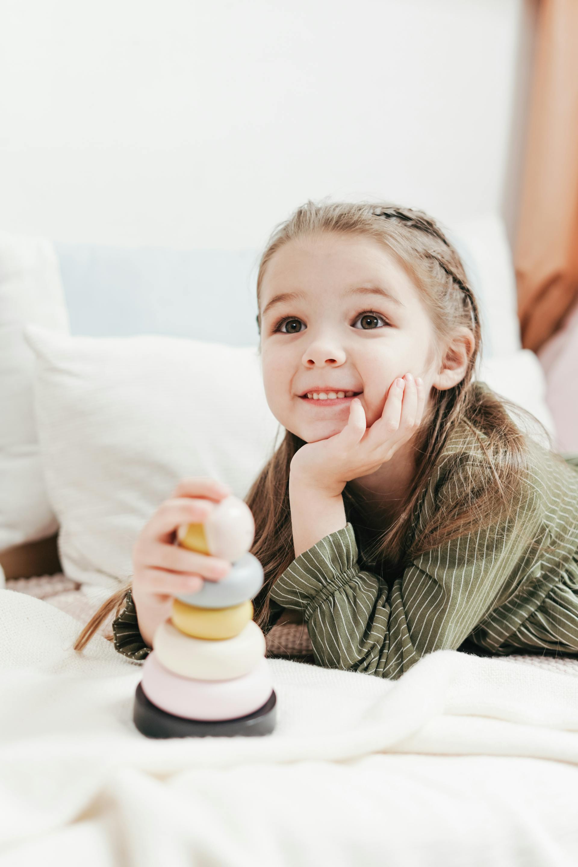 Une petite fille souriante avec un jouet | Source : Pexels