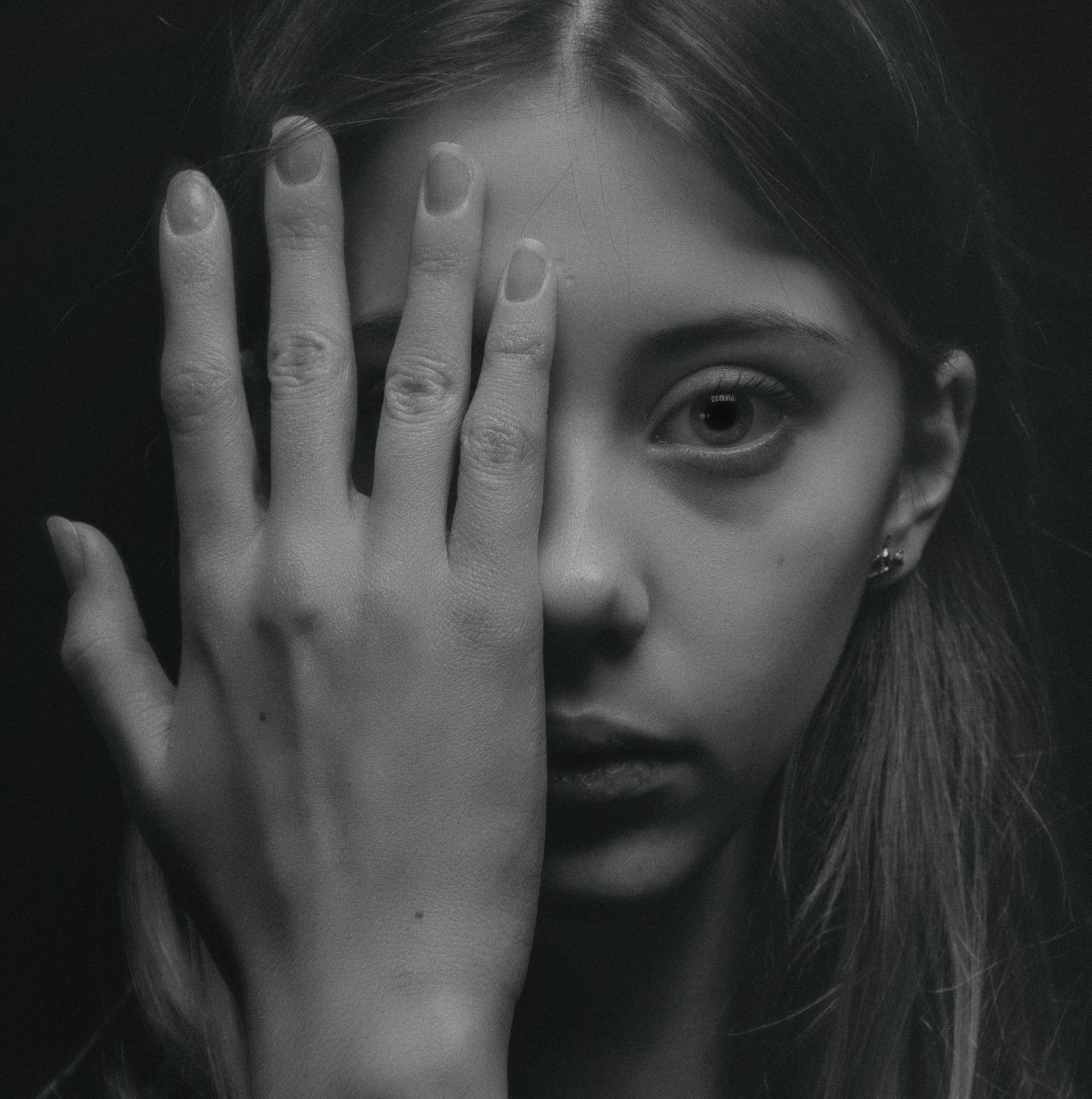 Photo d'une femme couvrant la moitié de son visage avec sa main | Source : Pexels