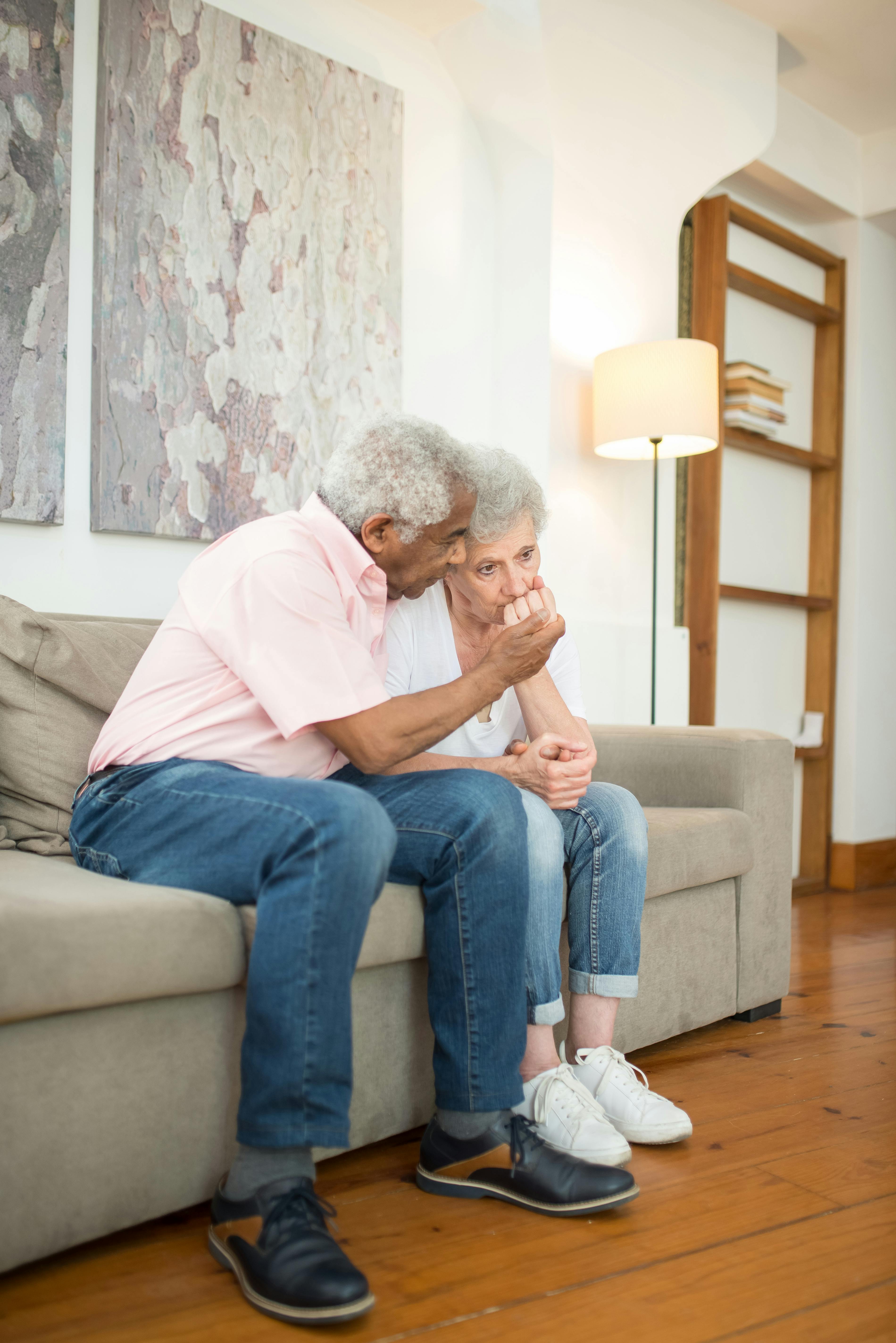 Un couple âgé et triste assis sur un canapé | Source : Pexels