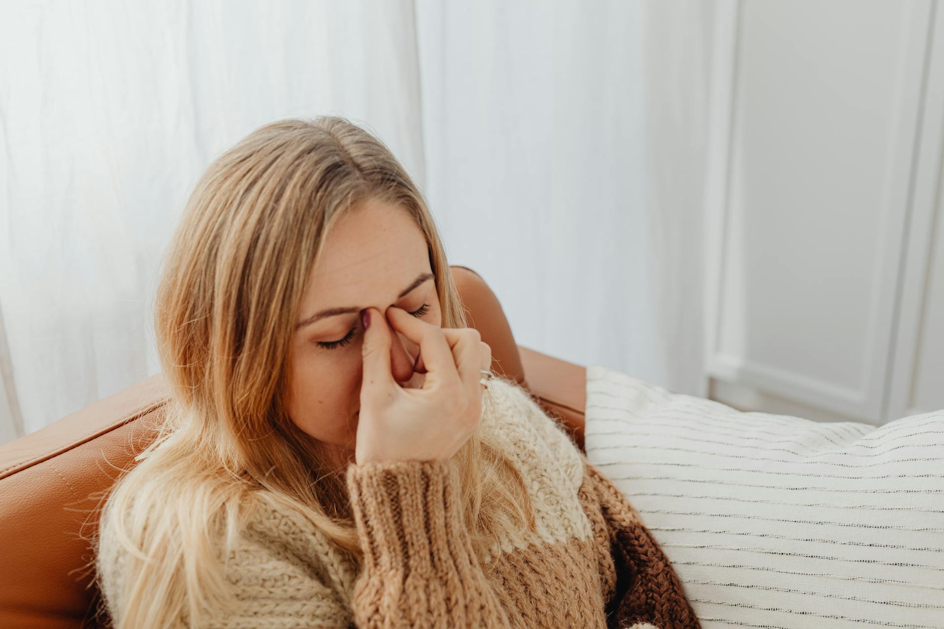 Une femme anxieuse assise sur le canapé | Source : Pexels