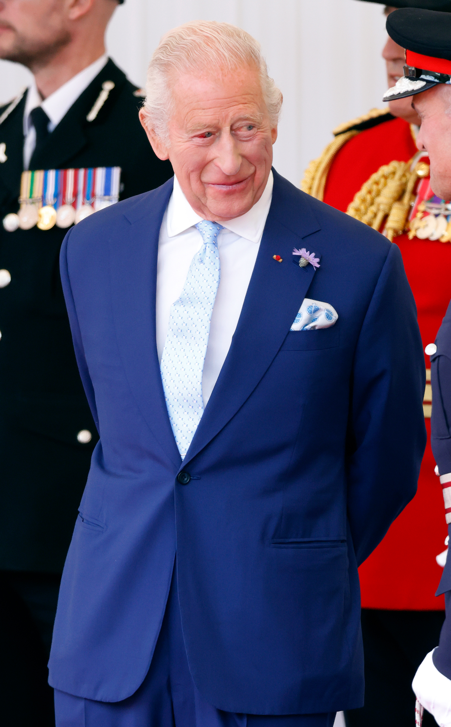 Le roi Charles III est vu debout avec des officiels sur l'estrade royale. Malgré un œil injecté de sang, le monarque semble serein lors de la visite d'État historique des Macron, la première de la France depuis 17 ans.