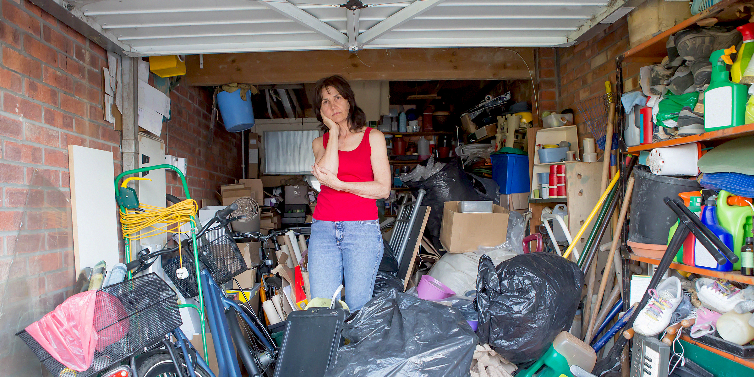 Une femme debout dans un garage rempli d'objets divers | Source : Shutterstock