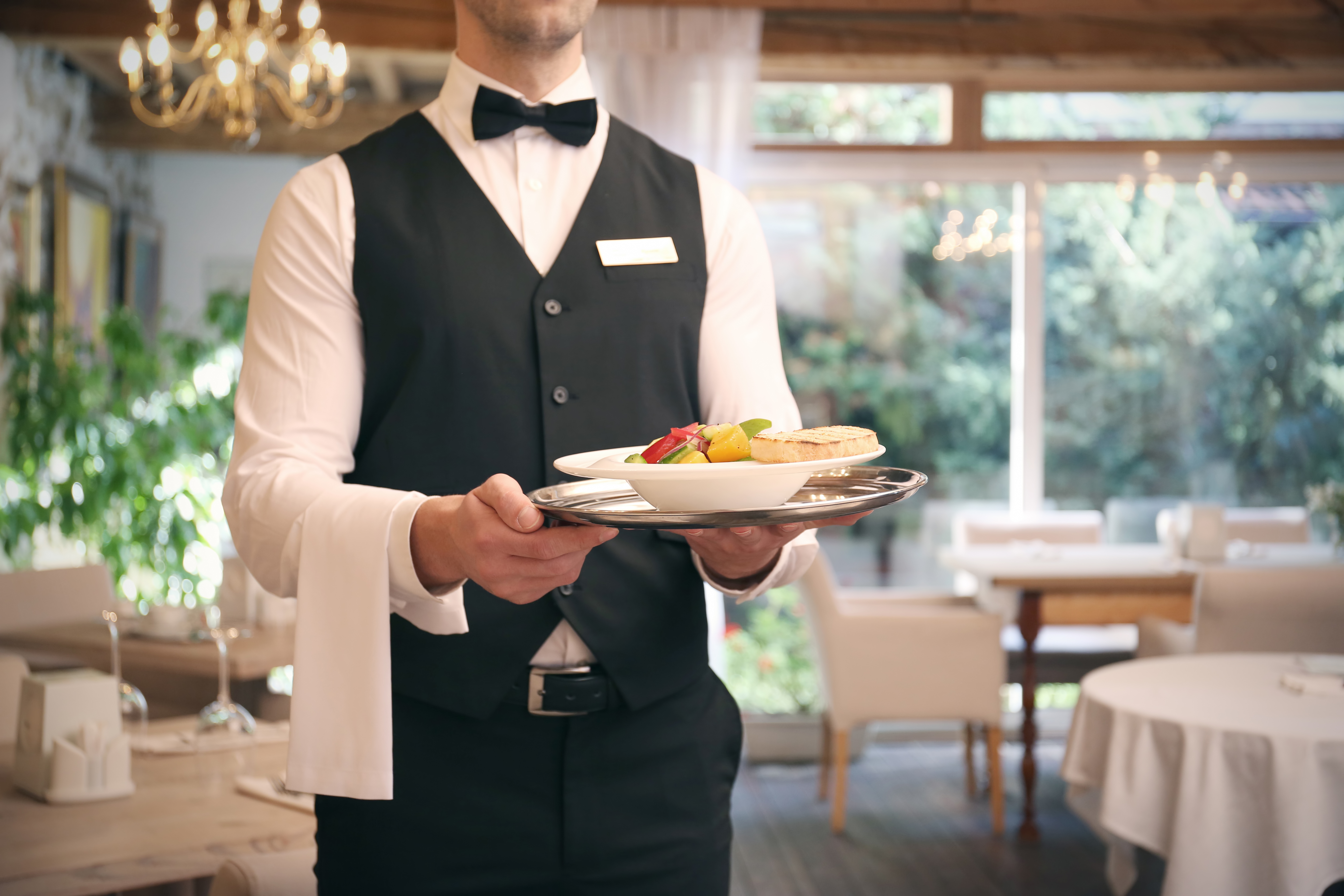 Un serveur sert la nourriture dans le restaurant | Source : Shutterstock