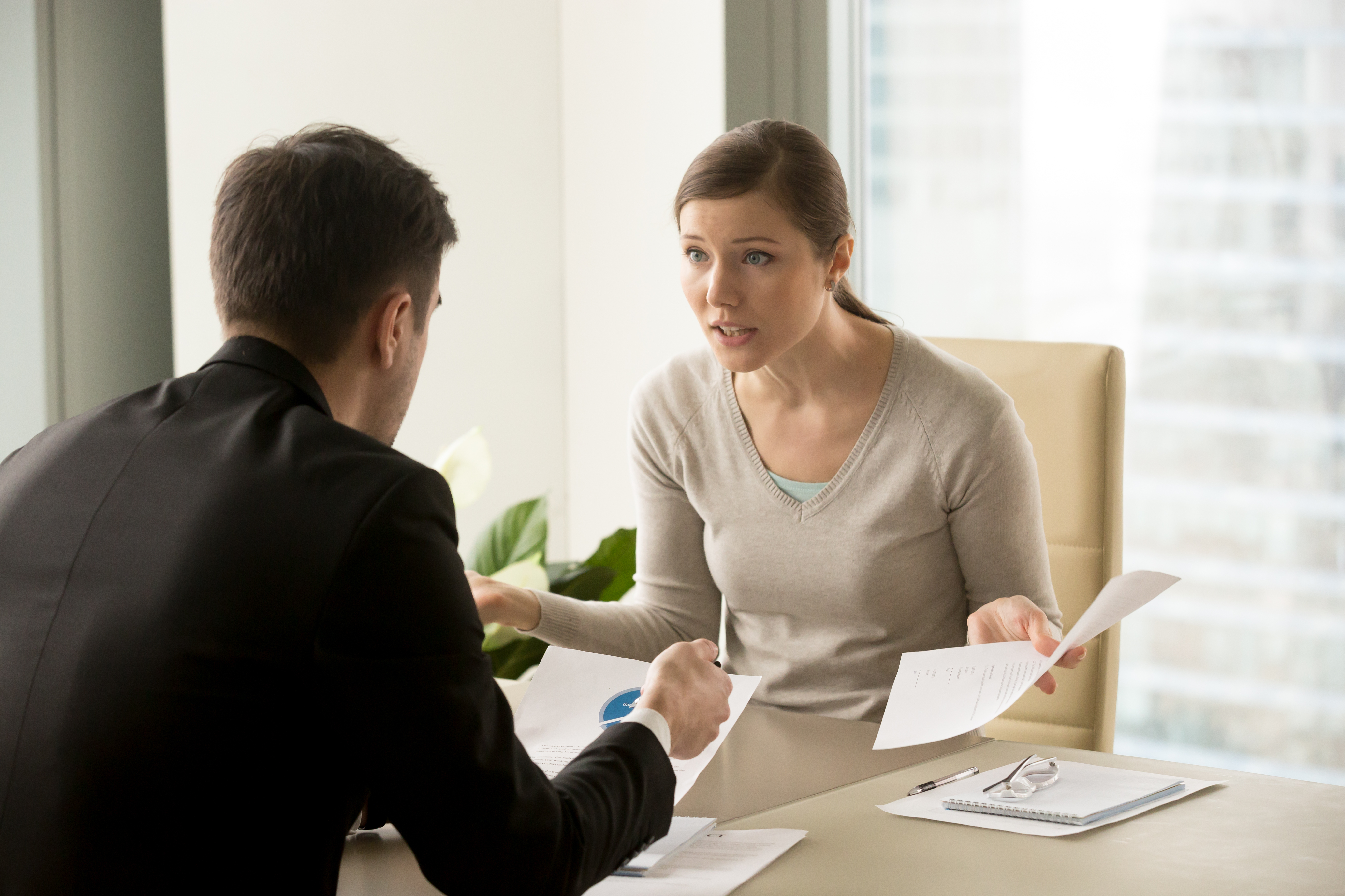 Uma mulher discutindo com um homem em um escritório | Fonte: Shutterstock