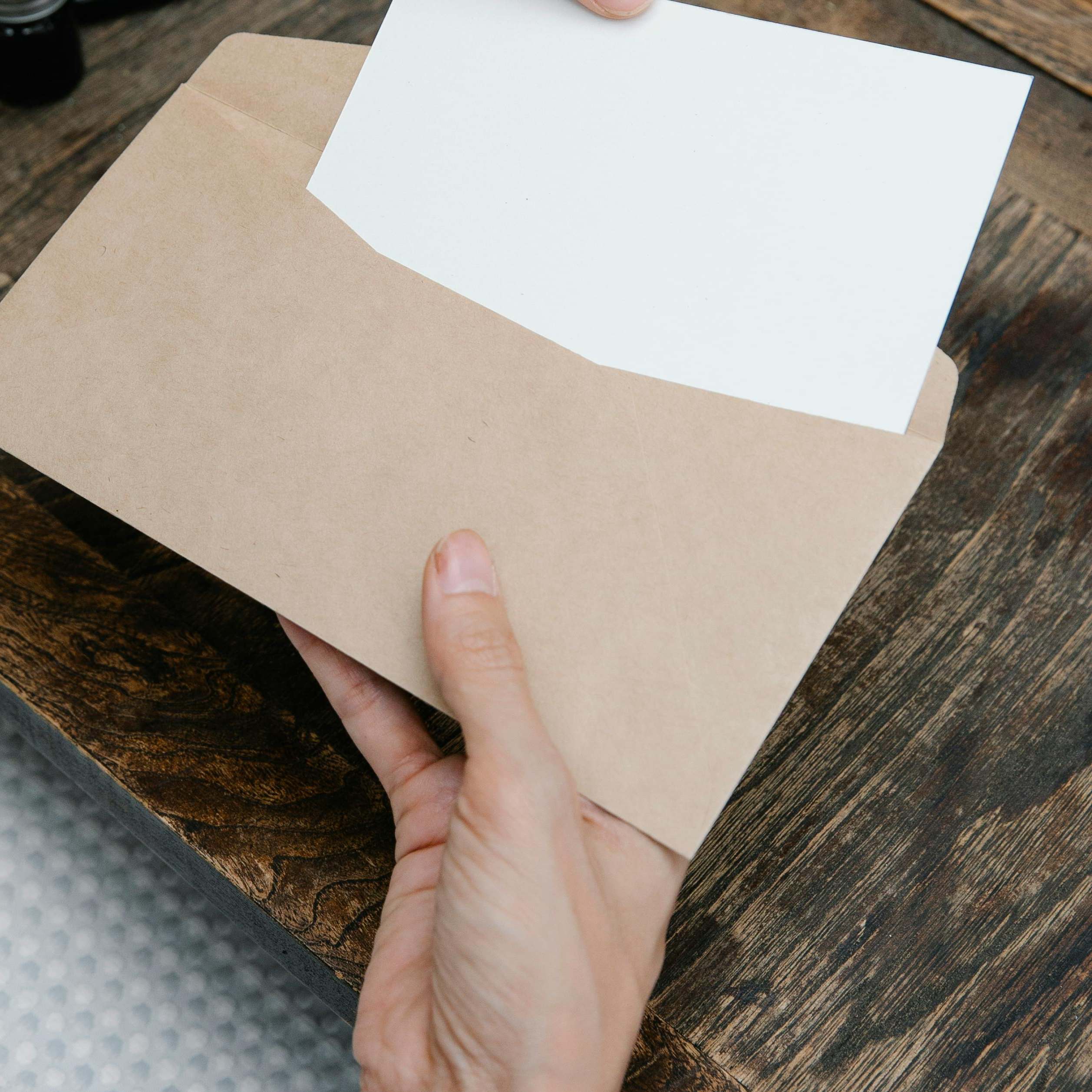 Une femme extrait un document d'une enveloppe | Source : Pexels