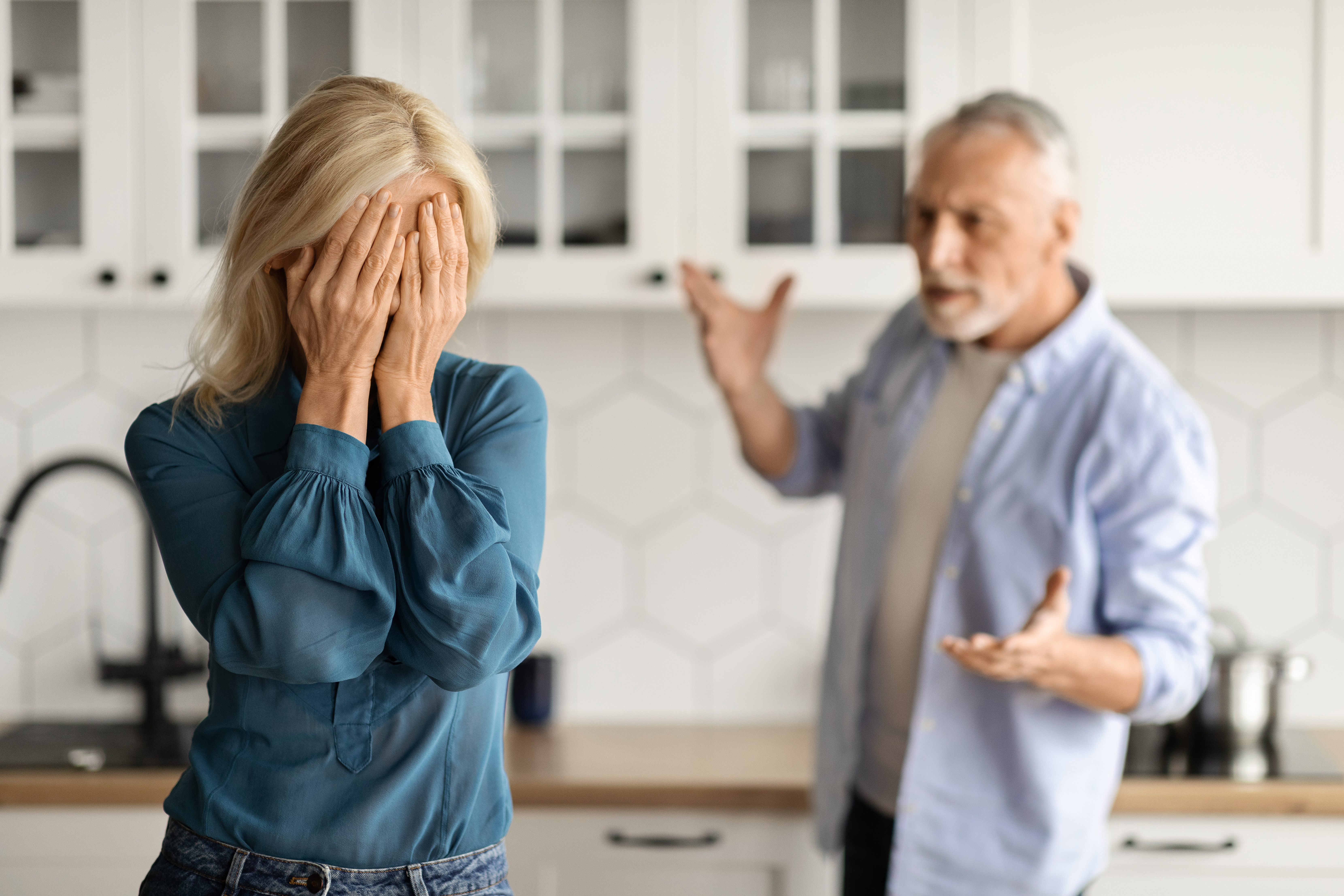 Un mari en colère se tient à l'arrière-plan et blâme sa femme | Source : Getty Images