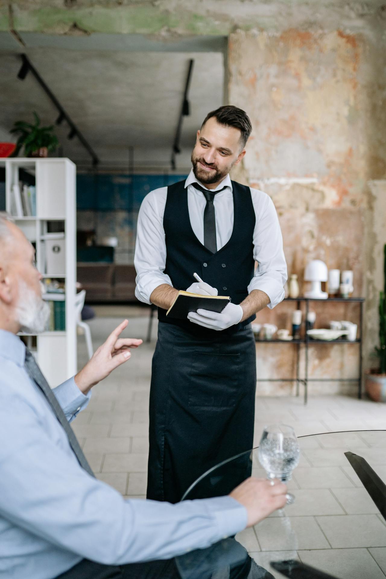 Un serveur prend la commande d'un client dans un restaurant | Source : Pexels