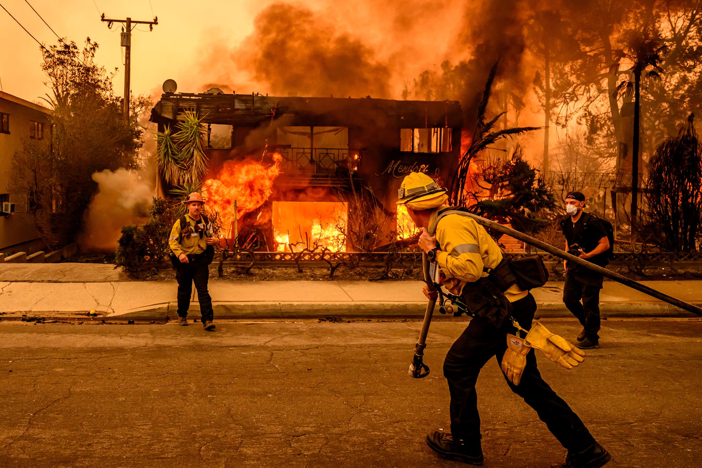 Les pompiers travaillent sur les lieux alors qu'un immeuble d'habitation brûle lors de l'incendie d'Eaton dans le quartier d'Altadena du comté de Los Angeles, en Californie, le 8 janvier 2025 | Source : Getty Images