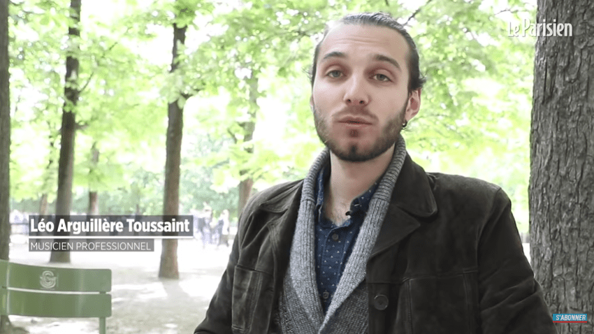 Un homme  joué de la guitare dans le Jardin du Luxembourg. | Photo : Youtube/Le Parisien