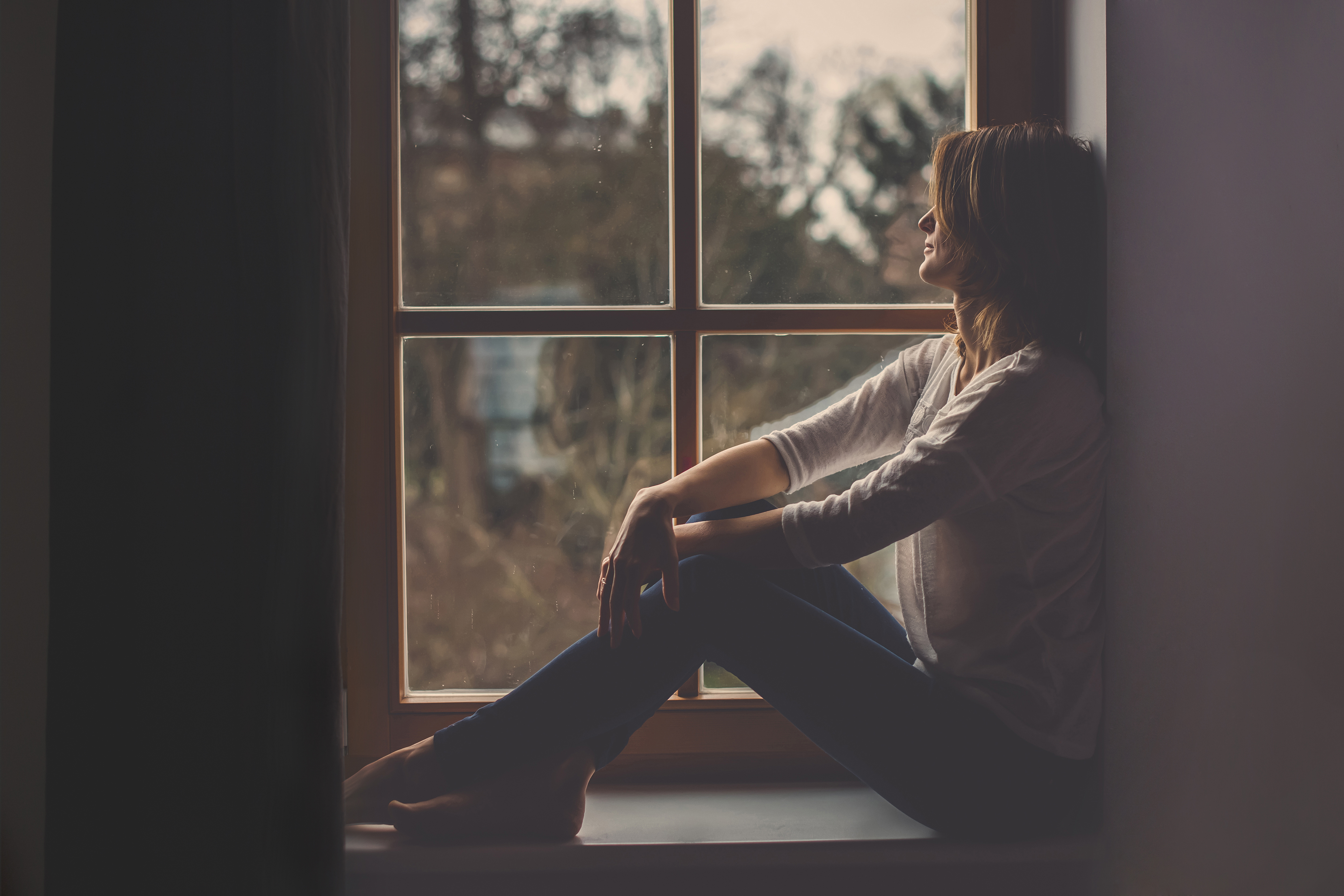 Femme seule assise près de la fenêtre | Source : Shutterstock