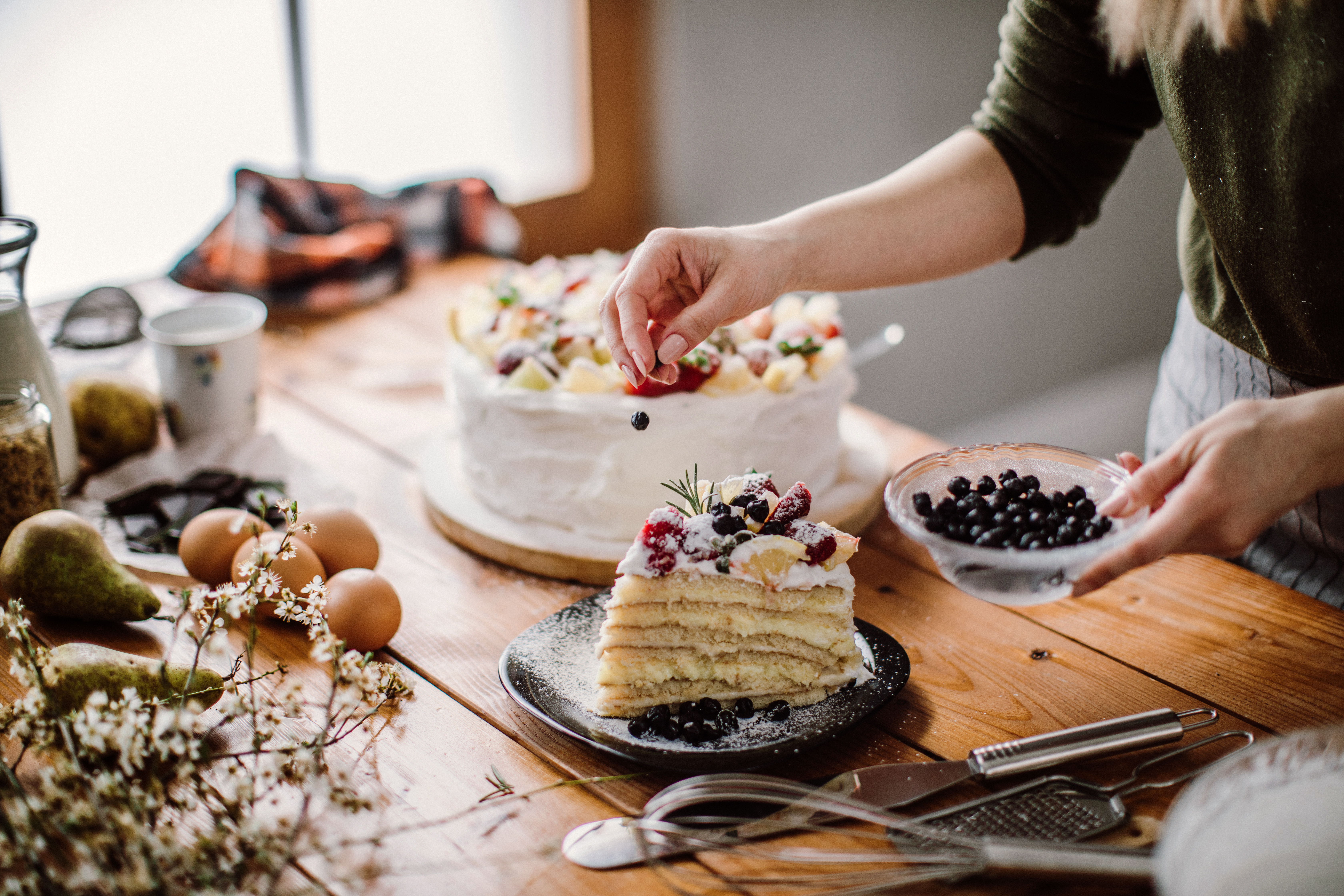 Une femme coupe un morceau de gâteau pour la personne qui fête son anniversaire | Source : Getty Images
