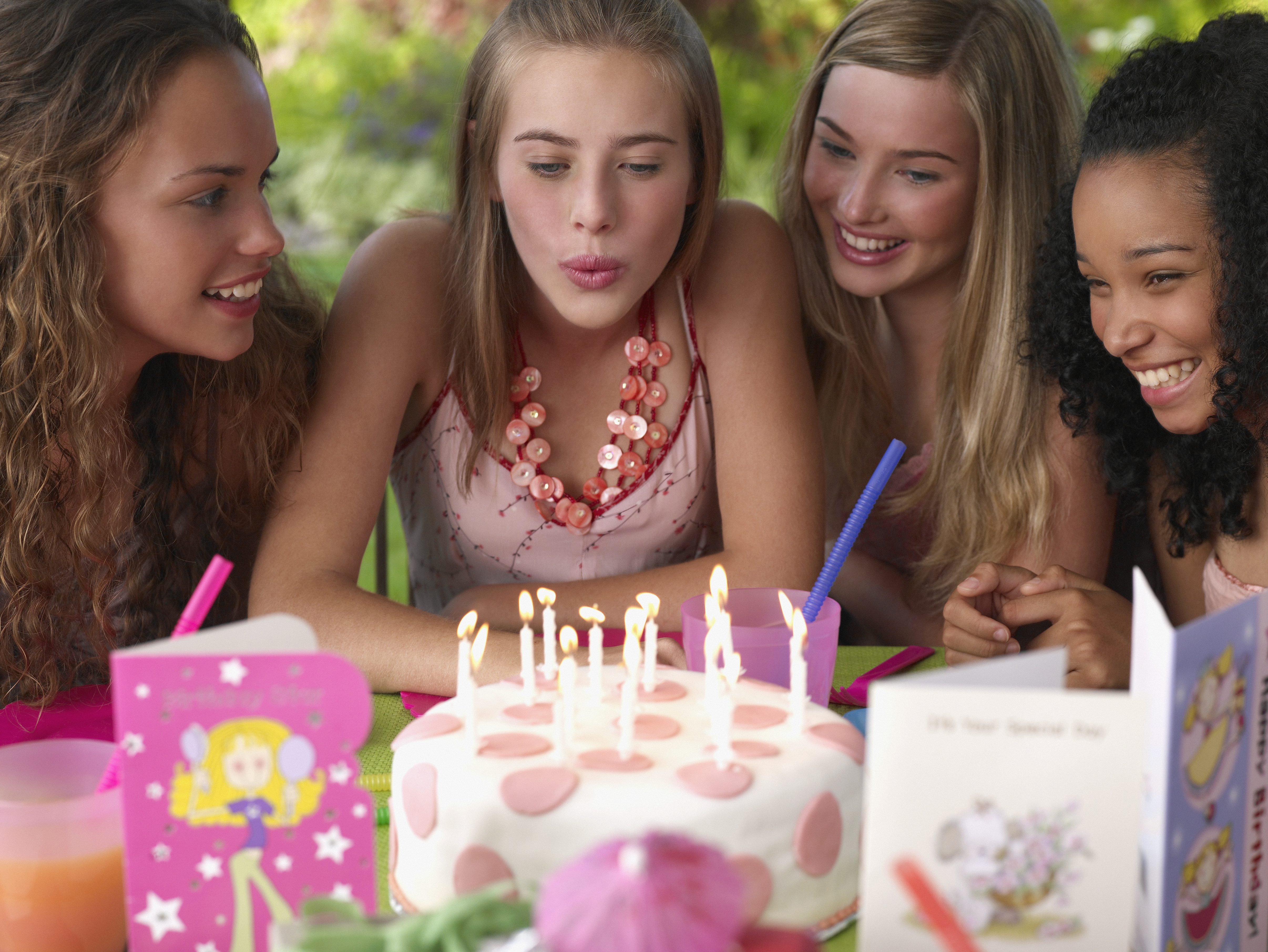 Quatre adolescentes à une fête d'anniversaire souriant à l'extérieur | Source : Getty Images
