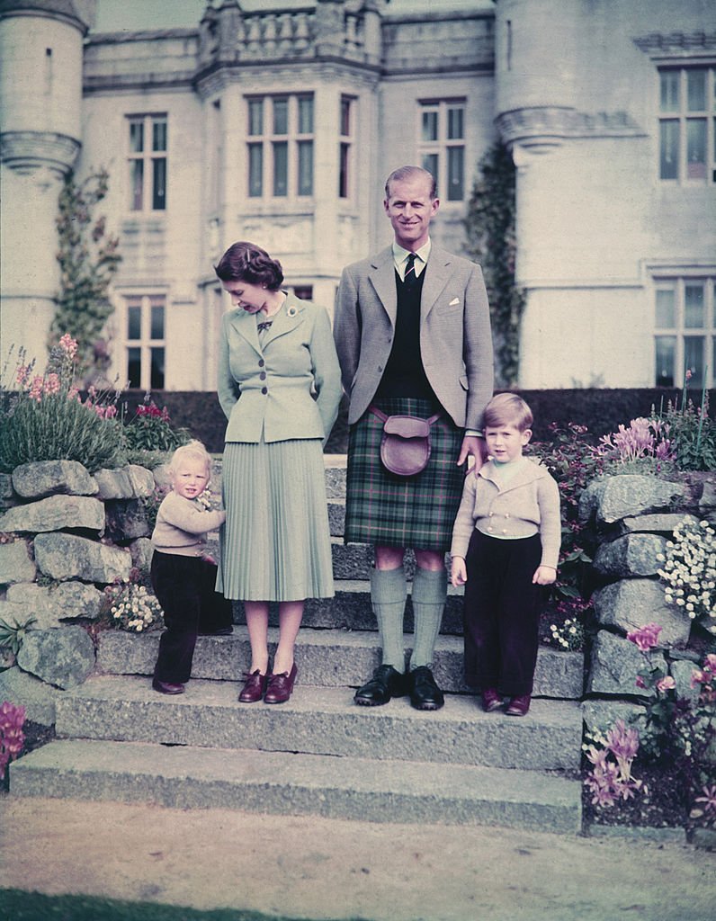 La reine Elizabeth II et le prince Philip, duc d'Édimbourg avec leurs deux jeunes enfants, la princesse Anne et le prince Charles devant le château de Balmoral, le 19 septembre 1952. | Photo : Getty Images