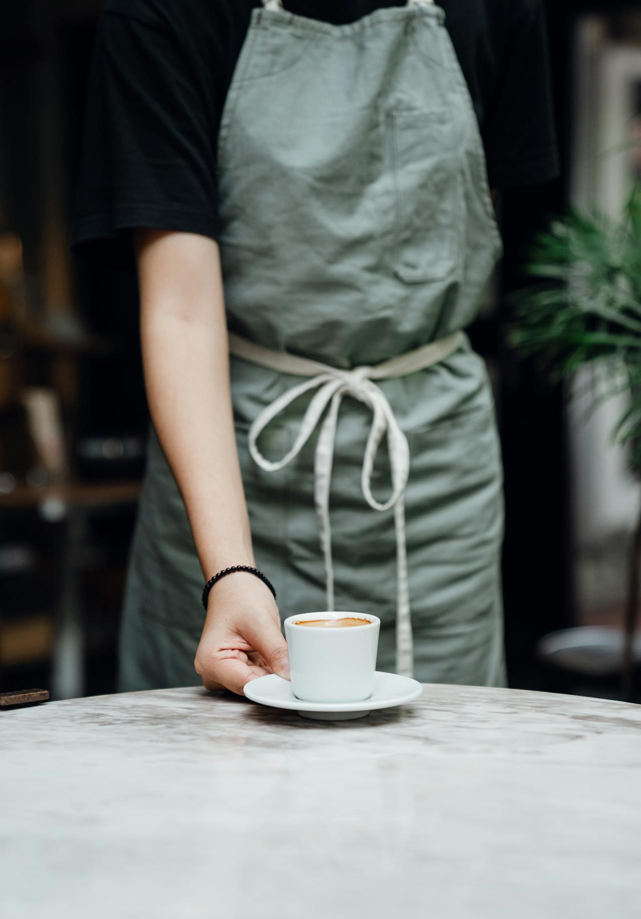 Une serveuse plaçant une tasse de café sur la table | Source : Pexels