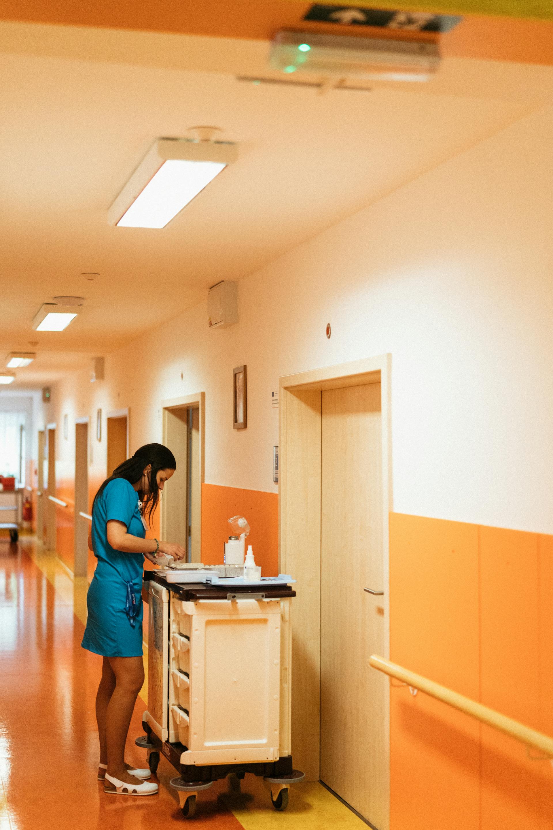 Une infirmière avec un chariot dans un couloir d'hôpital | Source : Pexels