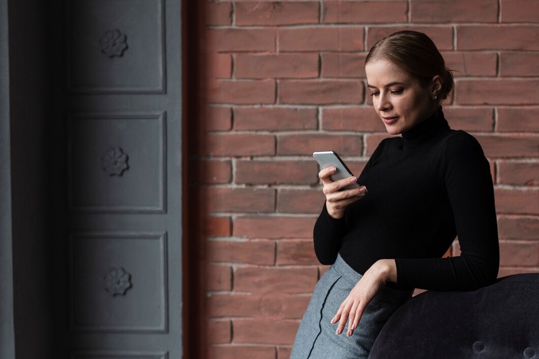 Une femme sérieuse sur son téléphone | Source : Freepik