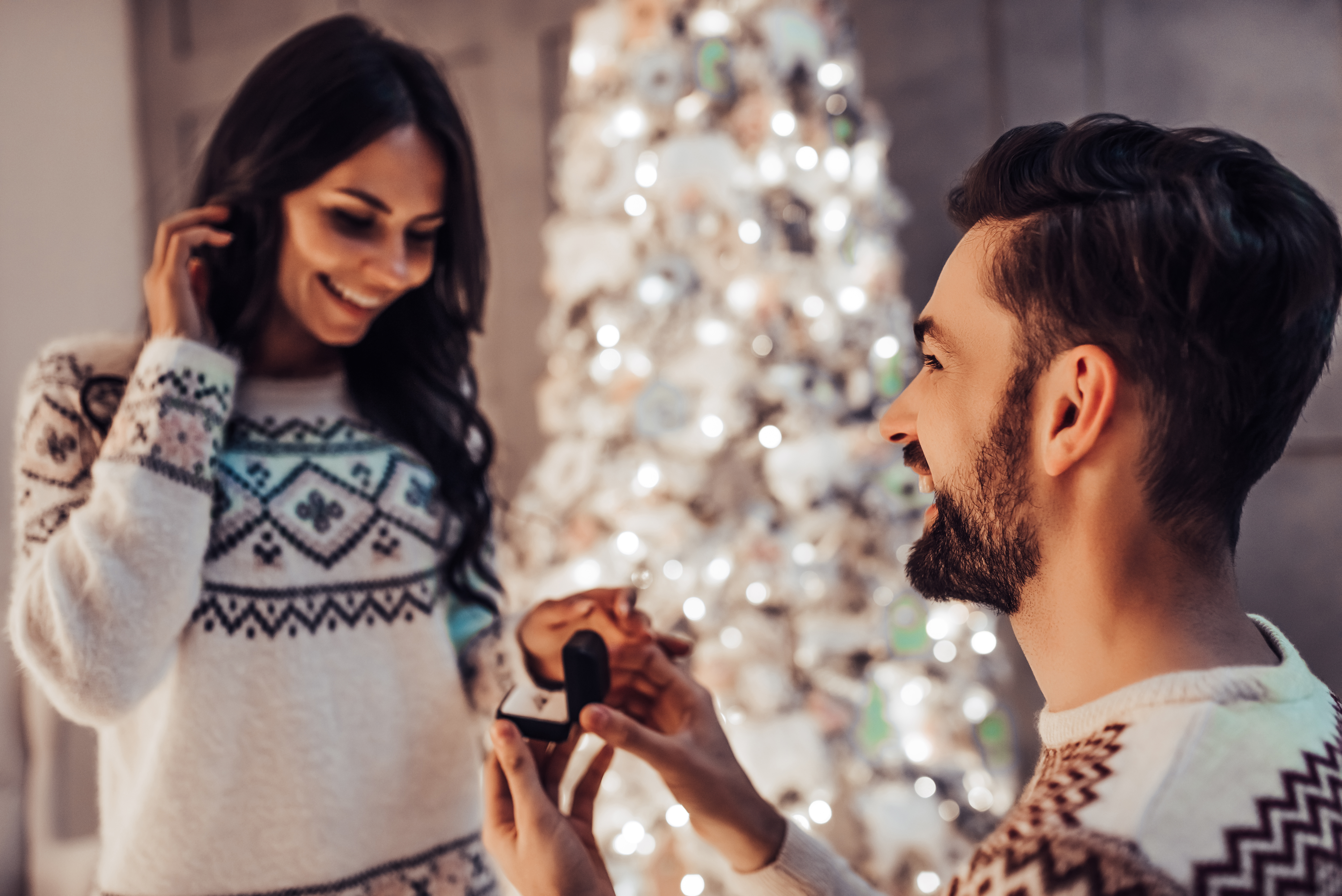 Un homme demande sa petite amie en mariage avec un arbre de Noël en arrière-plan | Source : Shutterstock