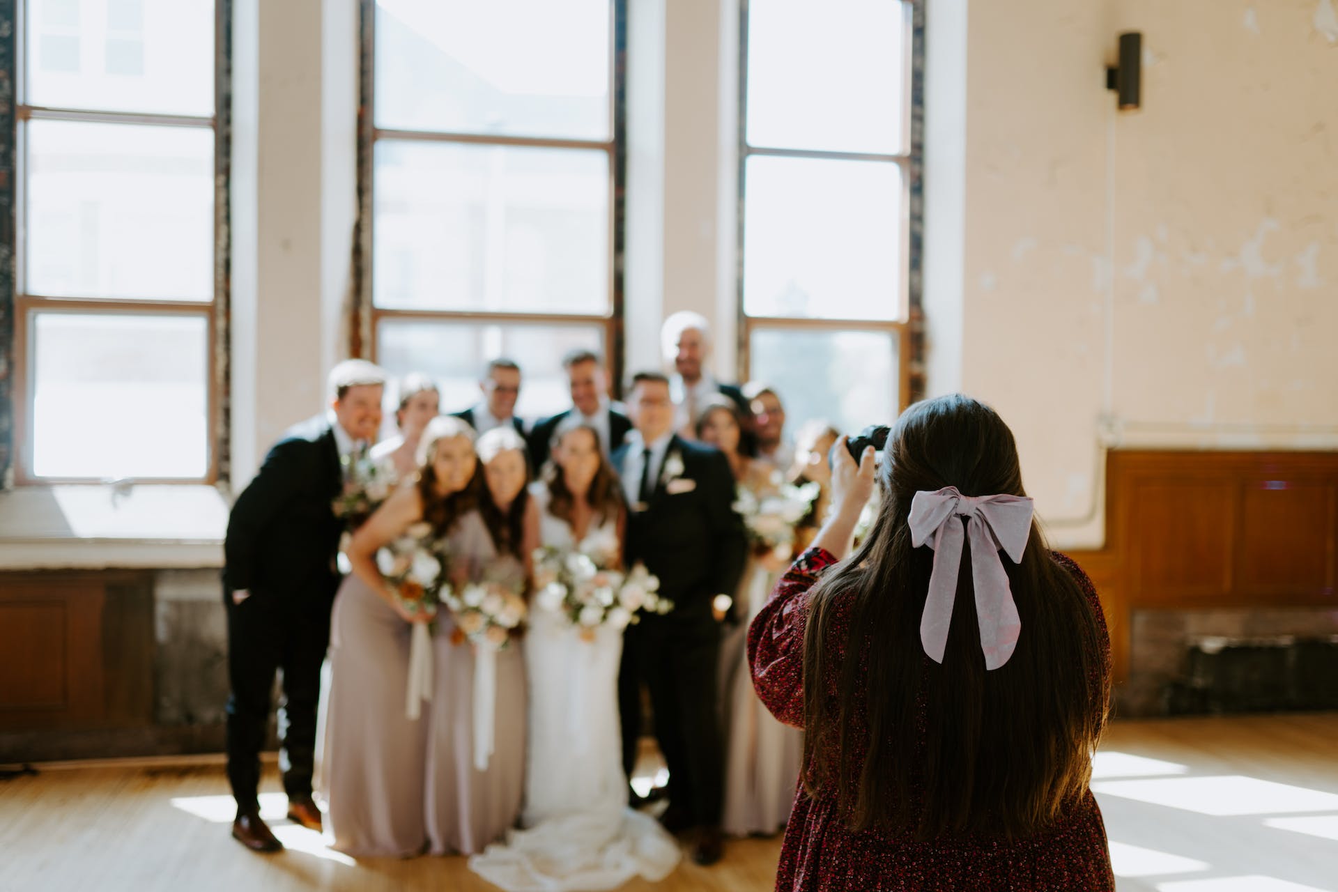 Um fotógrafo tirando uma foto de grupo em um casamento |  Fonte: Pexels