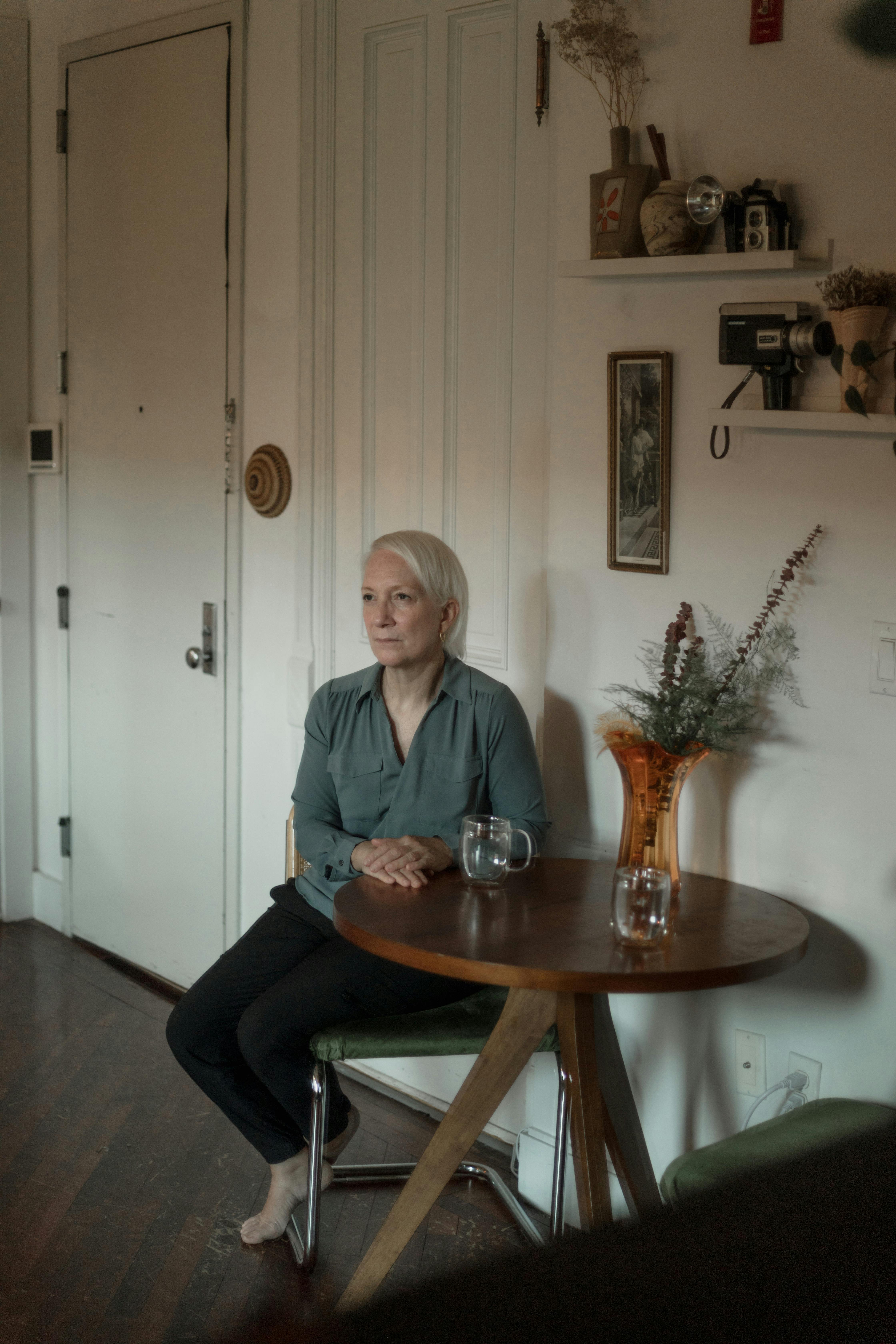 Une femme sérieuse assise à une table | Source : Pexels
