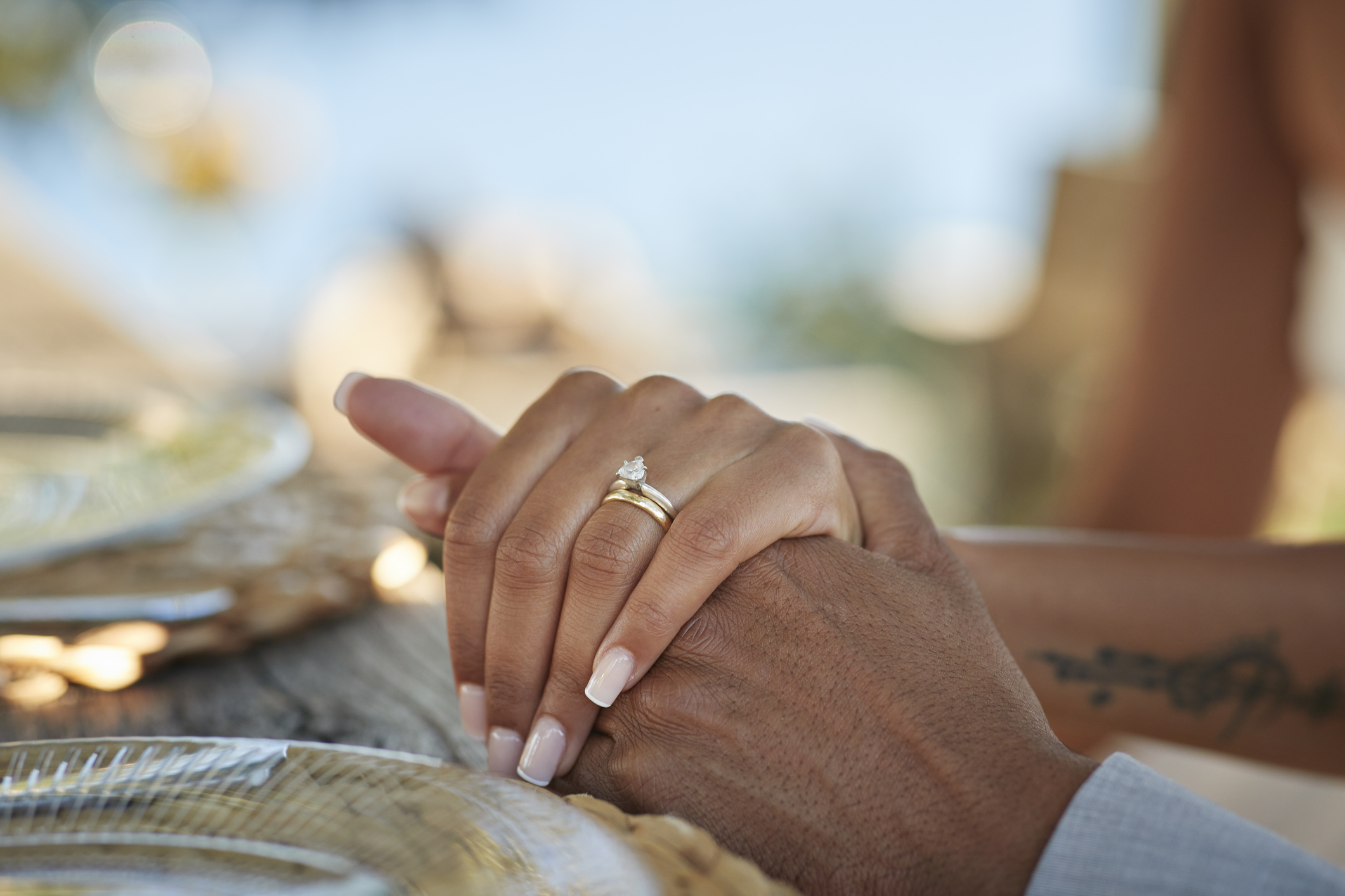 La mariée avec l'alliance tient la main du marié | Getty Images