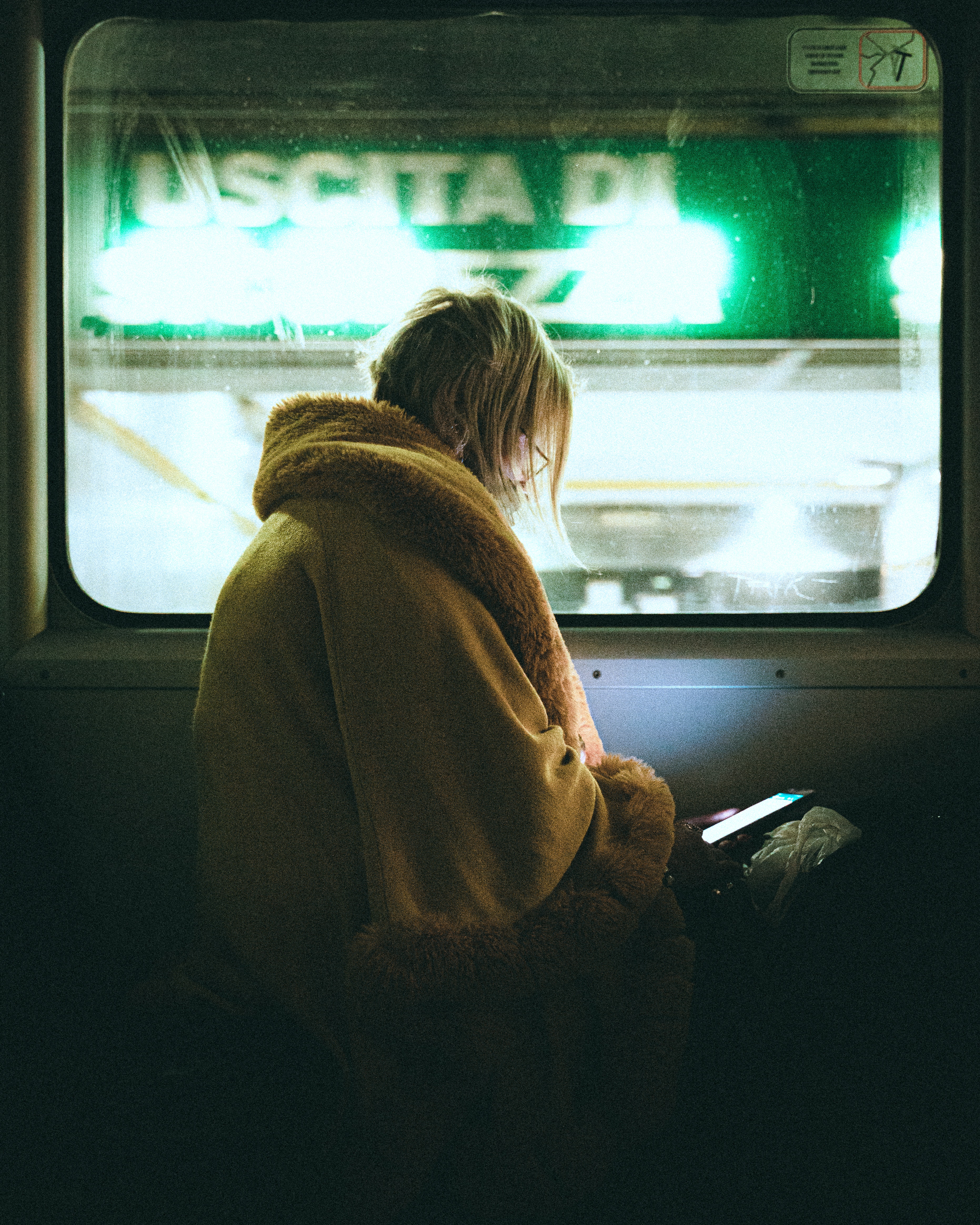 Une femme regardant son téléphone portable dans une cabine de train sombre | Source : Pexels