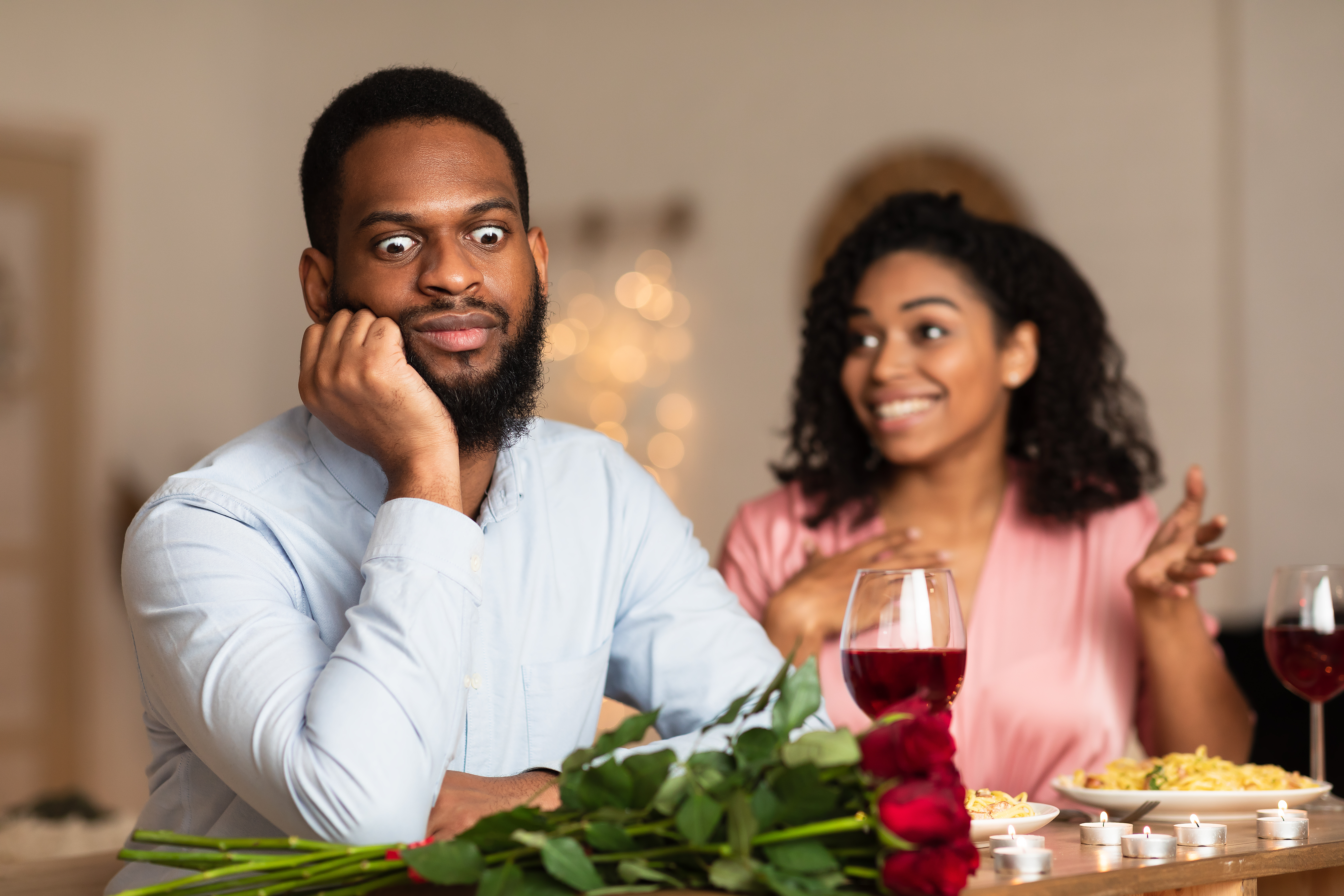 Homme noir insatisfait et choqué écoutant une femme excitée et émotive parler | Source : Shutterstock